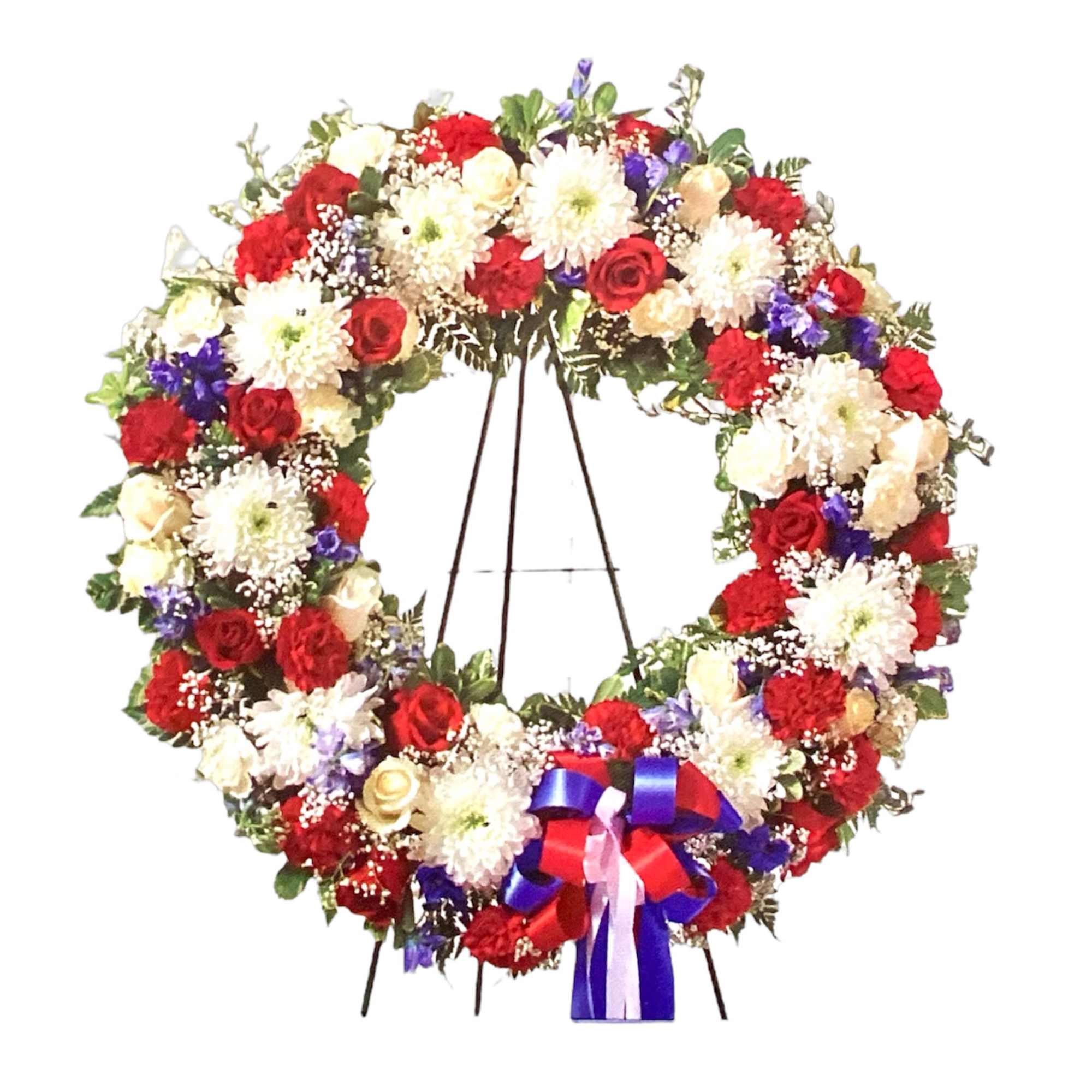Large floral wreath with red, white, and purple flowers on a stand