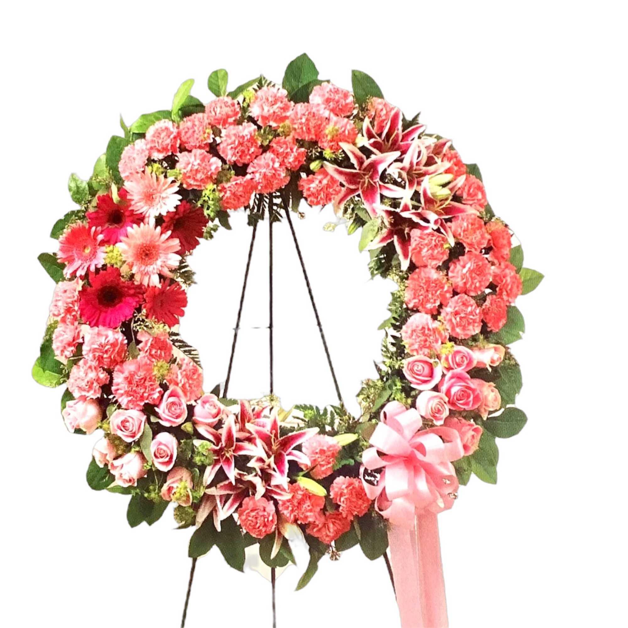Pink floral wreath on an easel with a ribbon bow