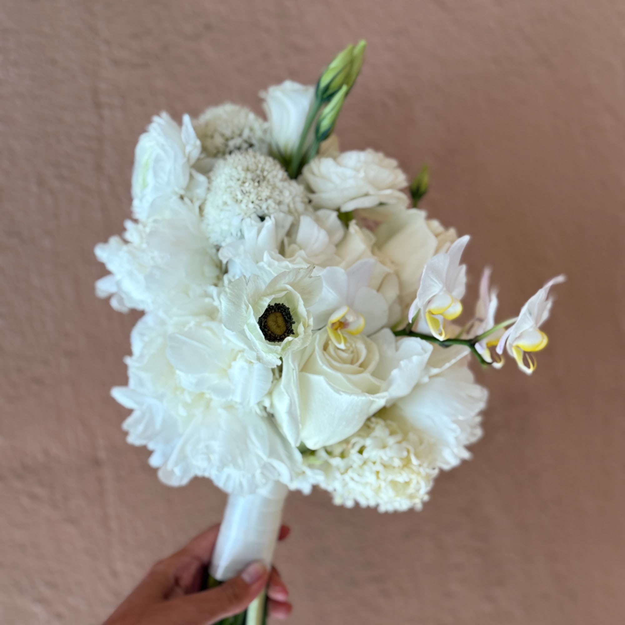 White bridal bouquet with roses, anemones, and orchids
