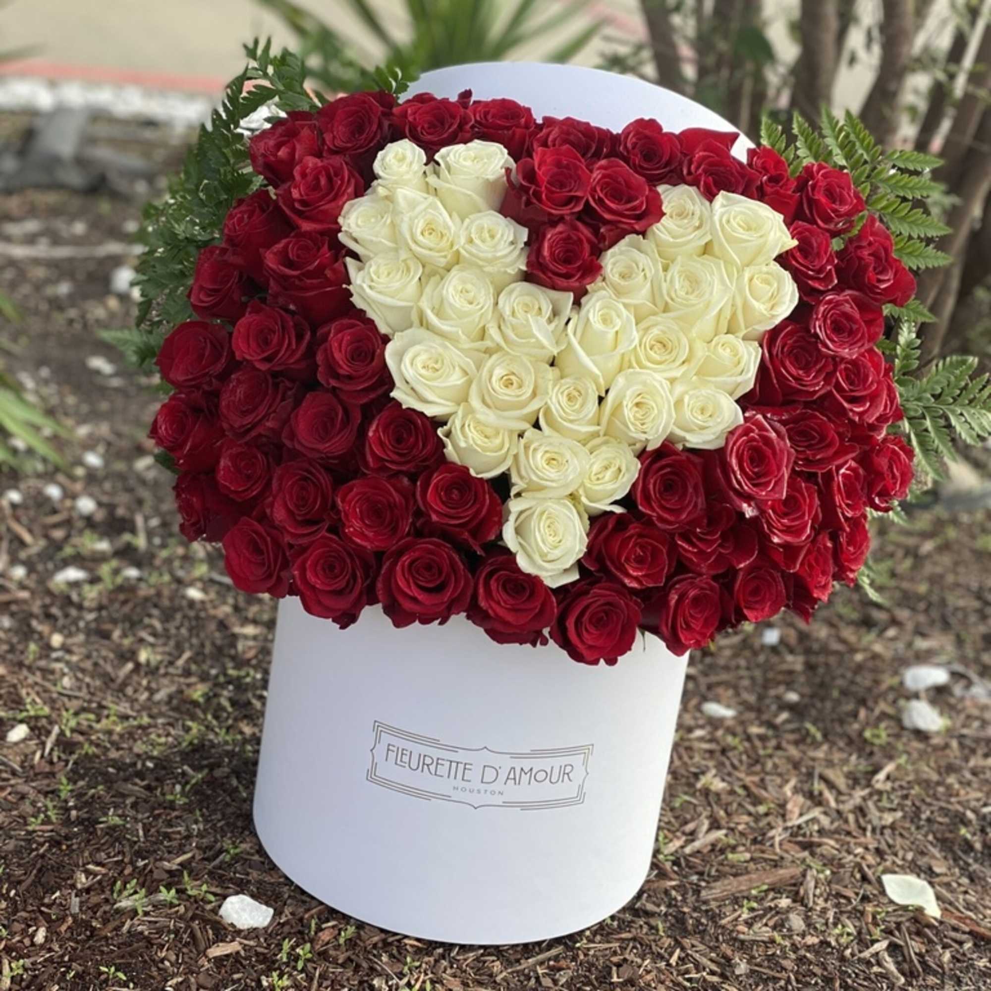 Heart-shaped bouquet of red and white roses in a white box