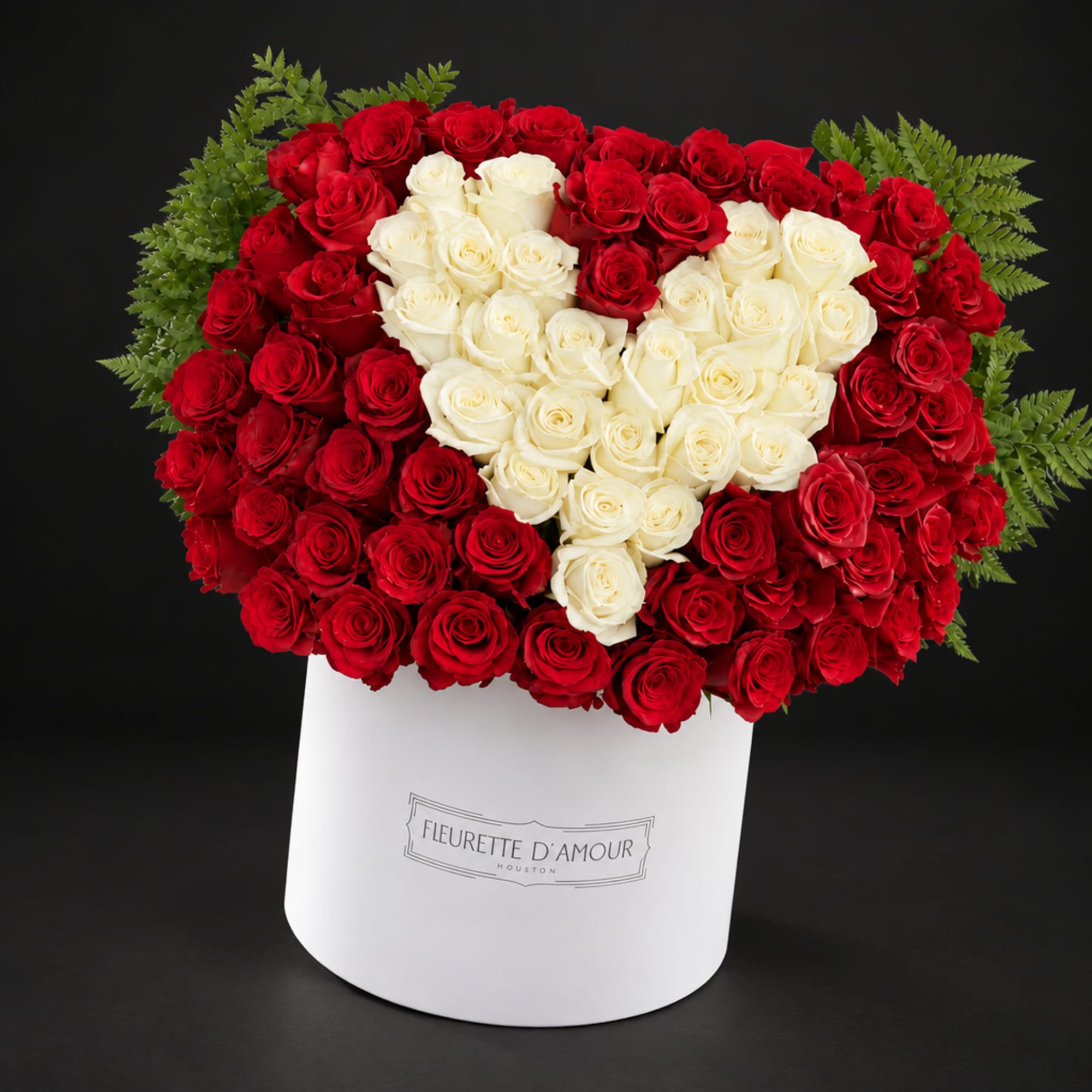 Heart-shaped red and white rose arrangement in a white box