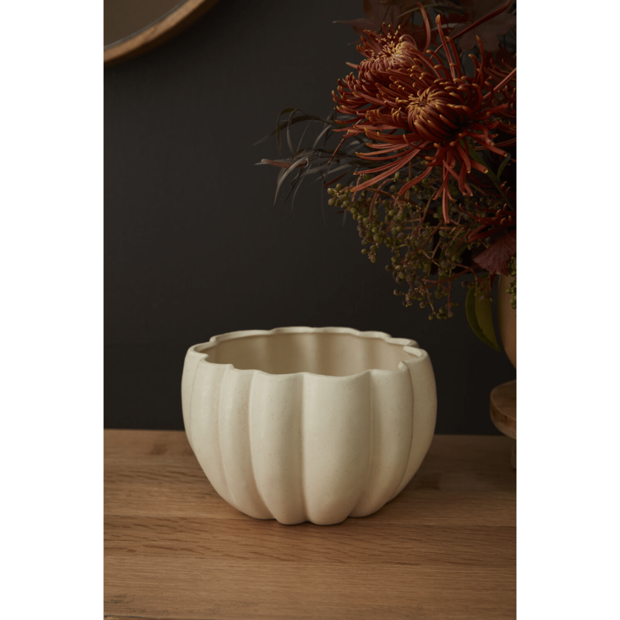 Cream pumpkin-shaped ceramic planter on a wooden surface
