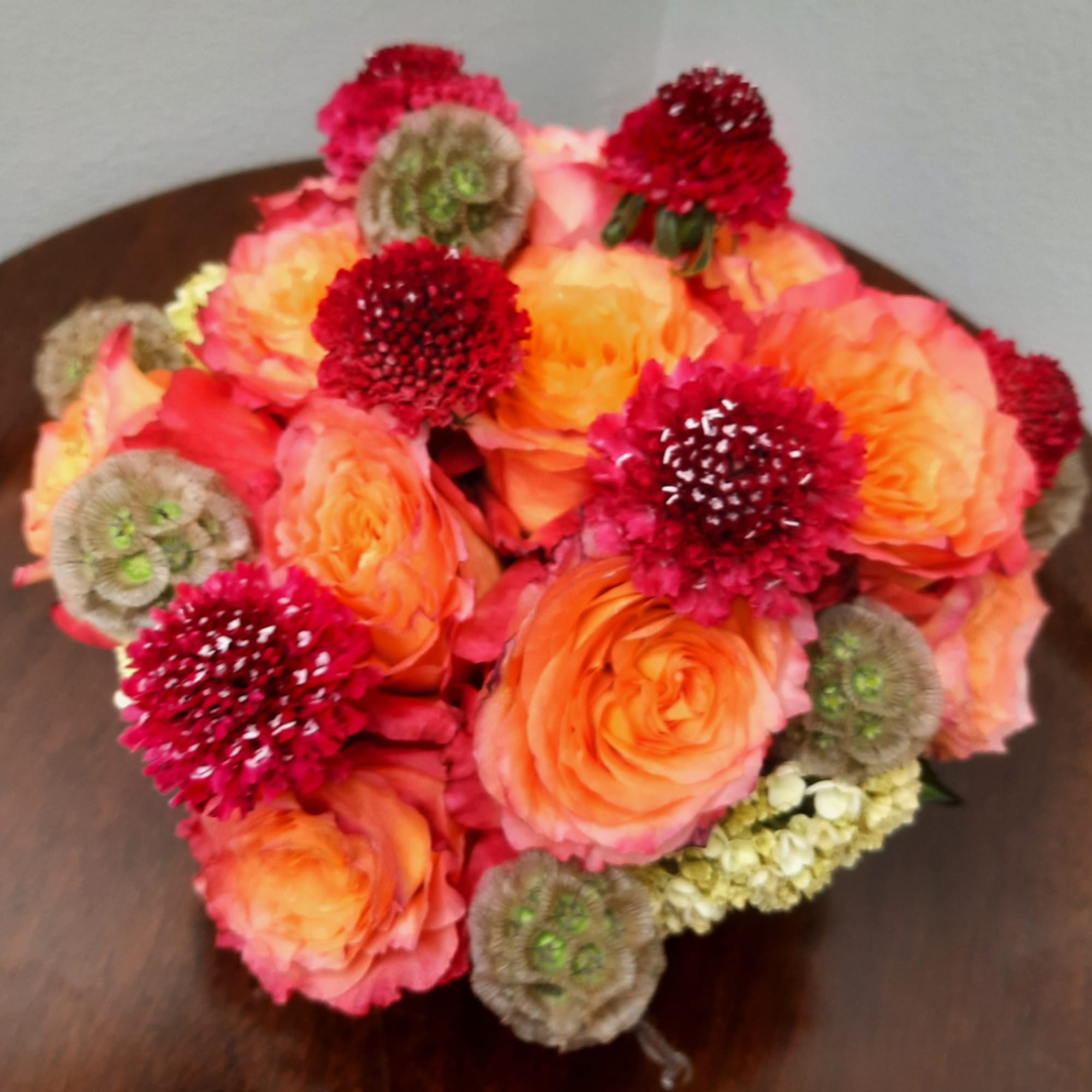 Bouquet of orange roses and red pom-pom flowers