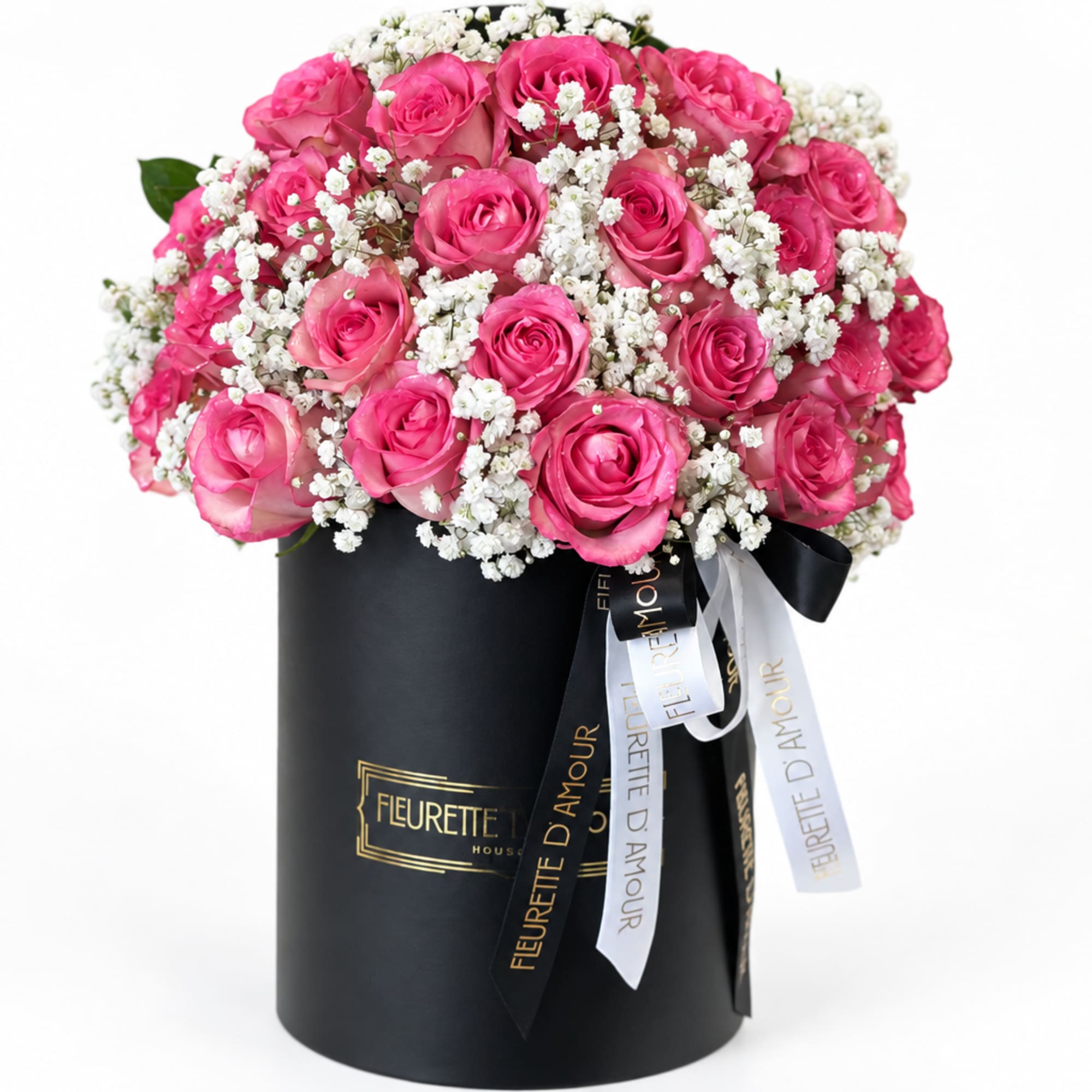 Pink roses and white baby's breath in a black cylindrical box with ribbons
