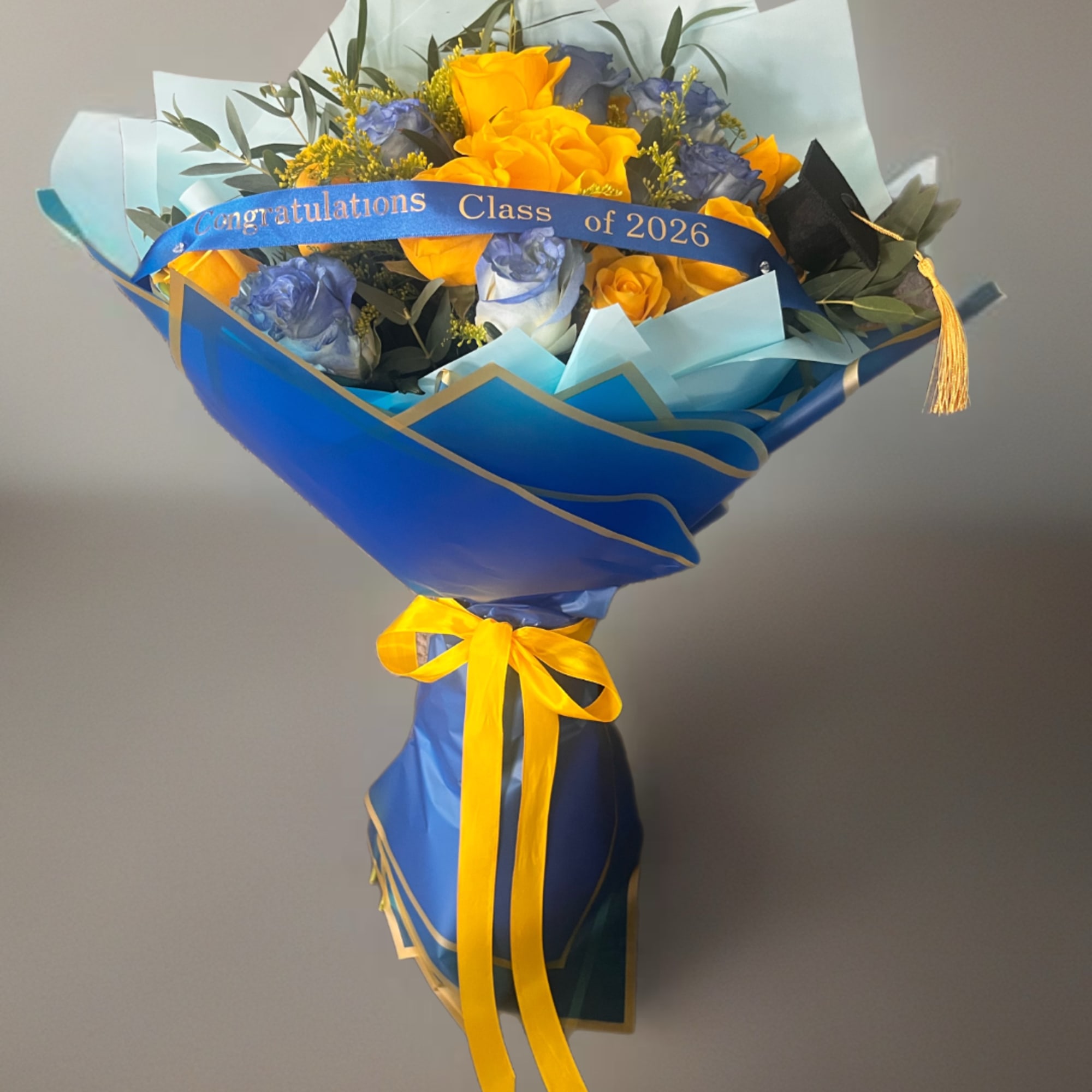 Blue and gold bouquet of yellow and blue roses with a graduation ribbon