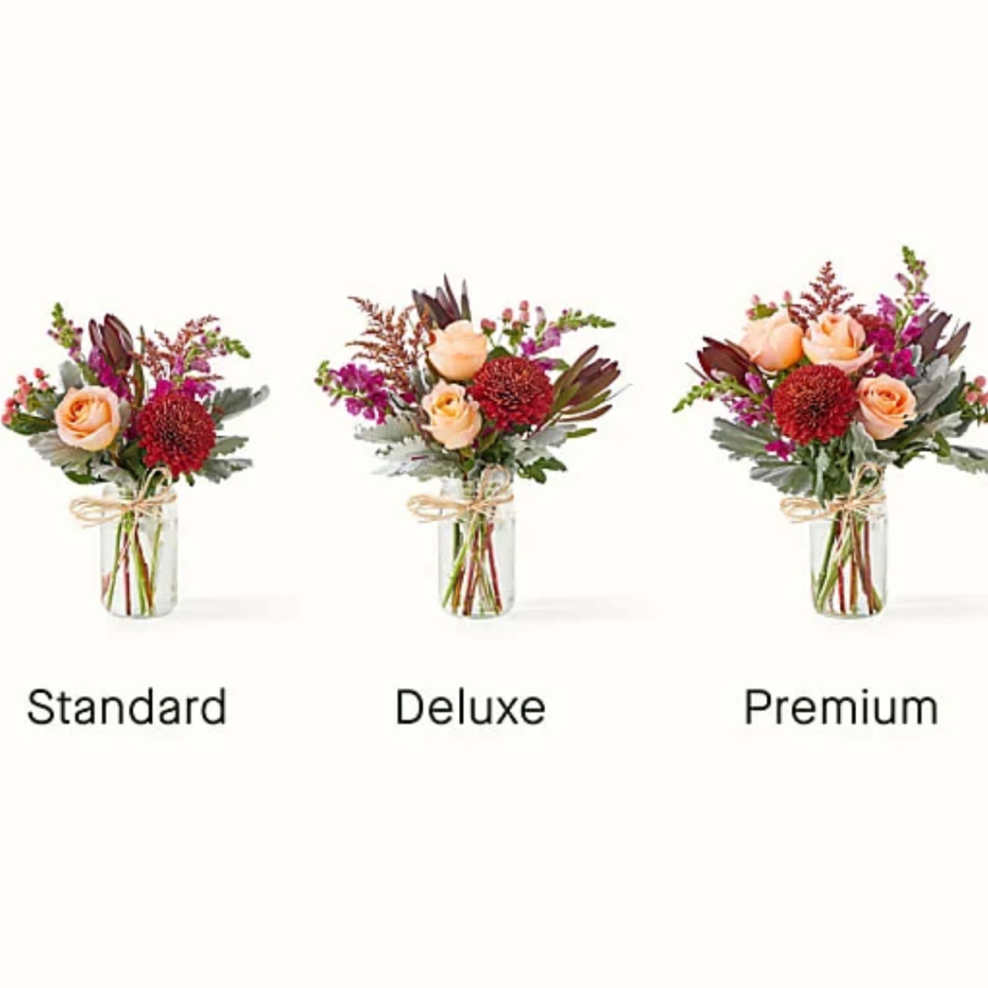 Three small floral arrangements in glass vases labeled Standard, Deluxe, and Premium