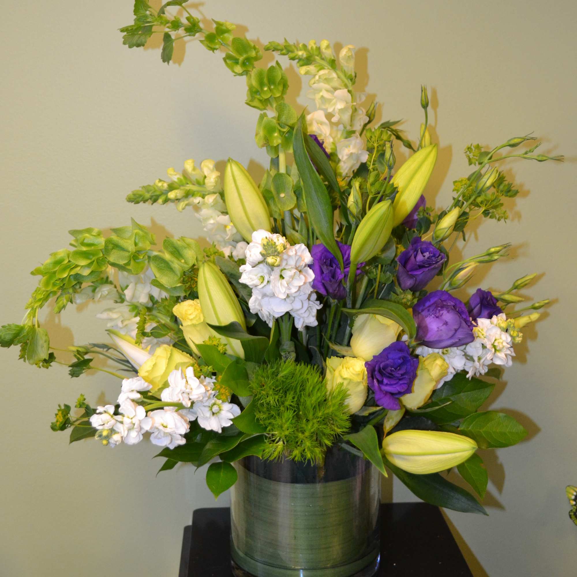 Arrangement of purple and white flowers in a glass vase
