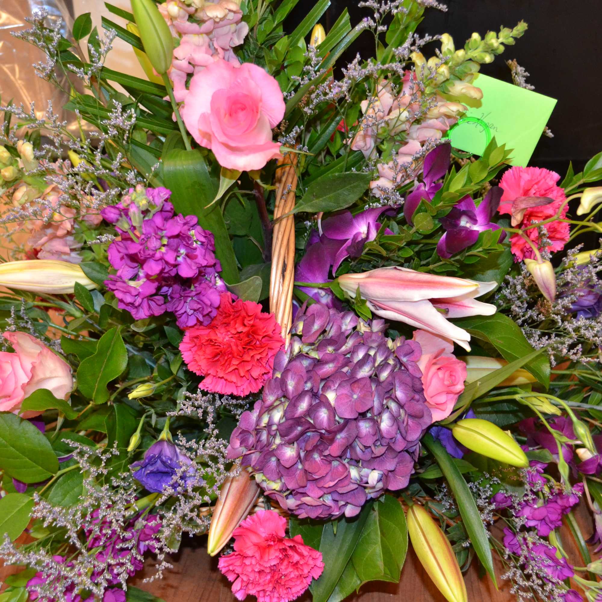Mixed bouquet with pink, purple, and white flowers in a basket