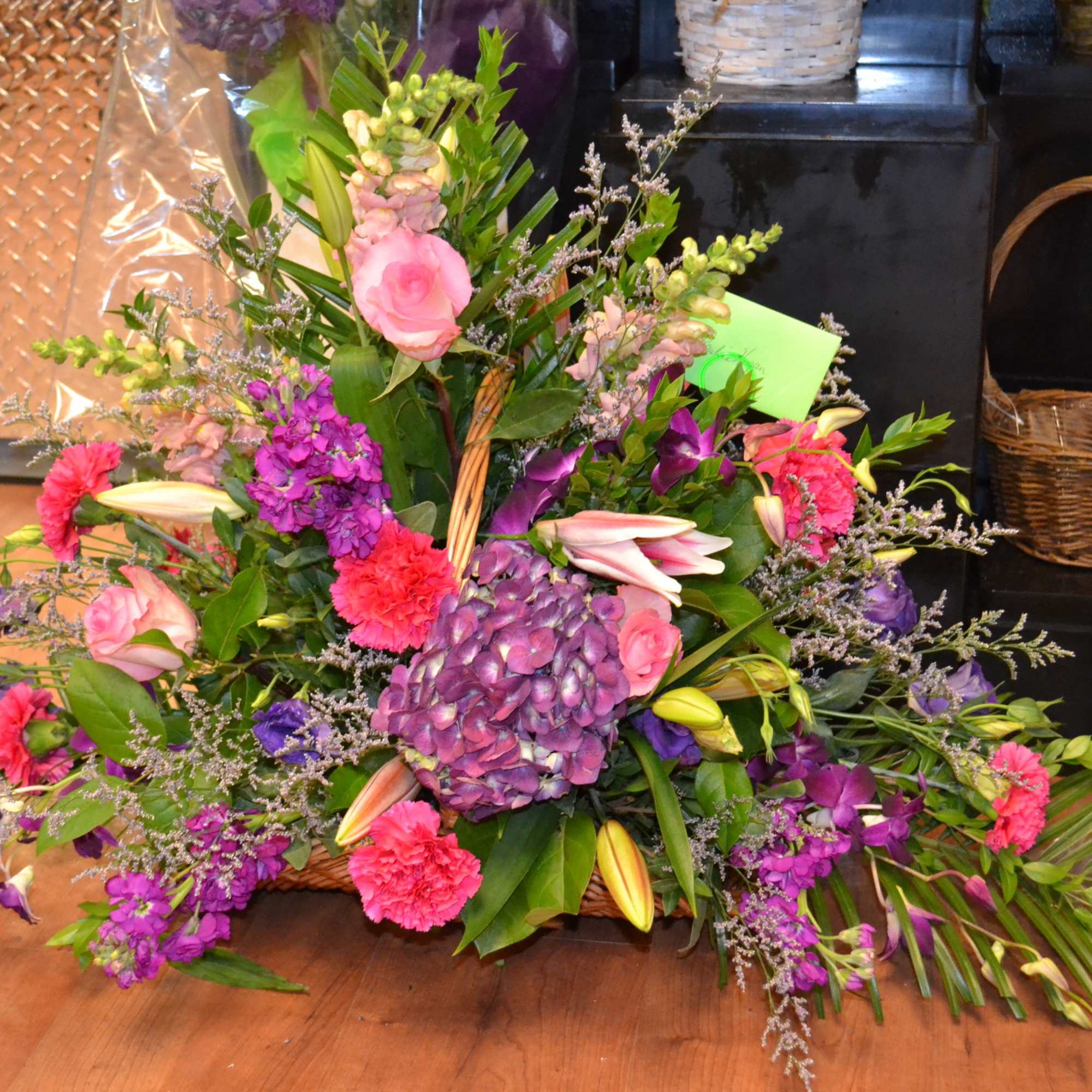 Large mixed floral arrangement with pink, purple, and white blooms in a basket