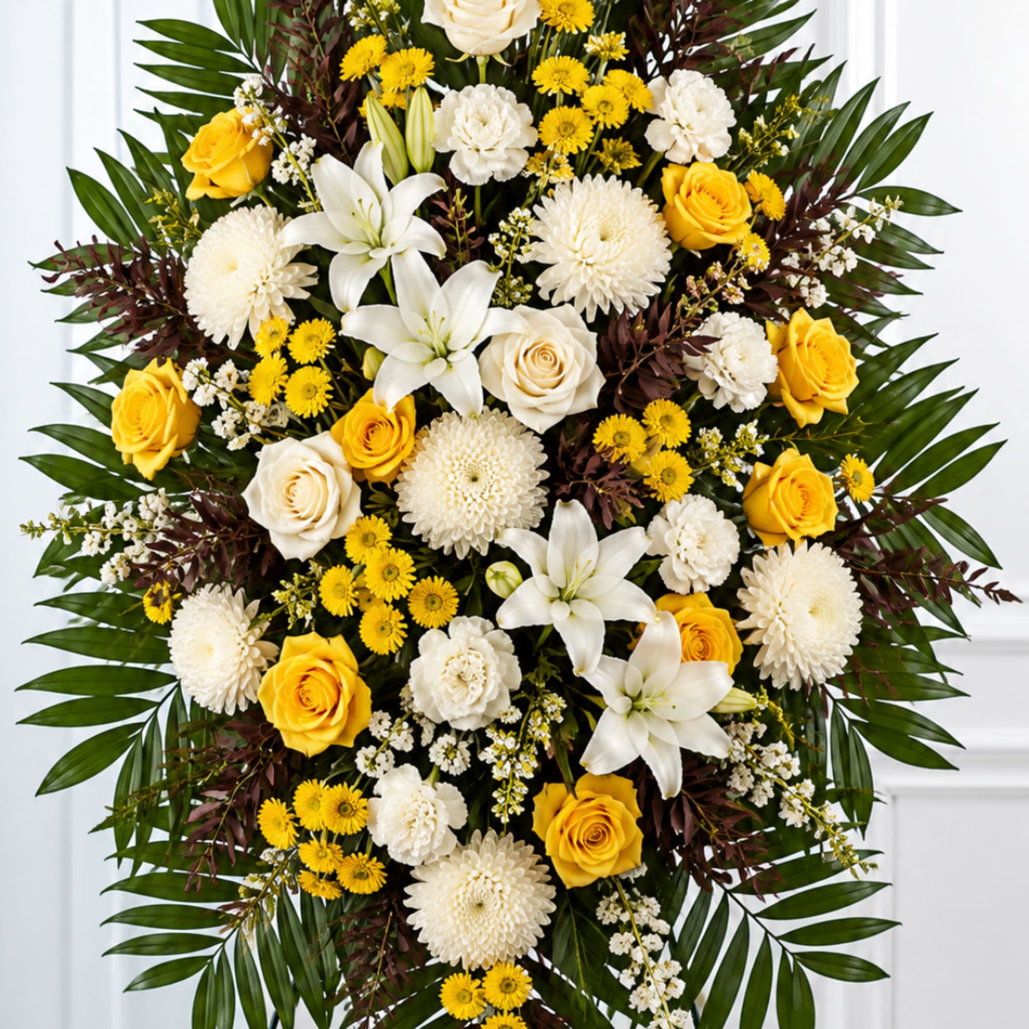 Yellow roses and white lilies arranged in a large standing spray