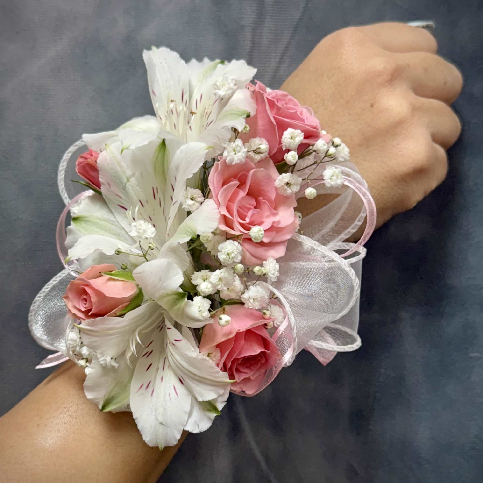 Pink spray roses and white alstroemeria with delicate filler and sheer ribbon