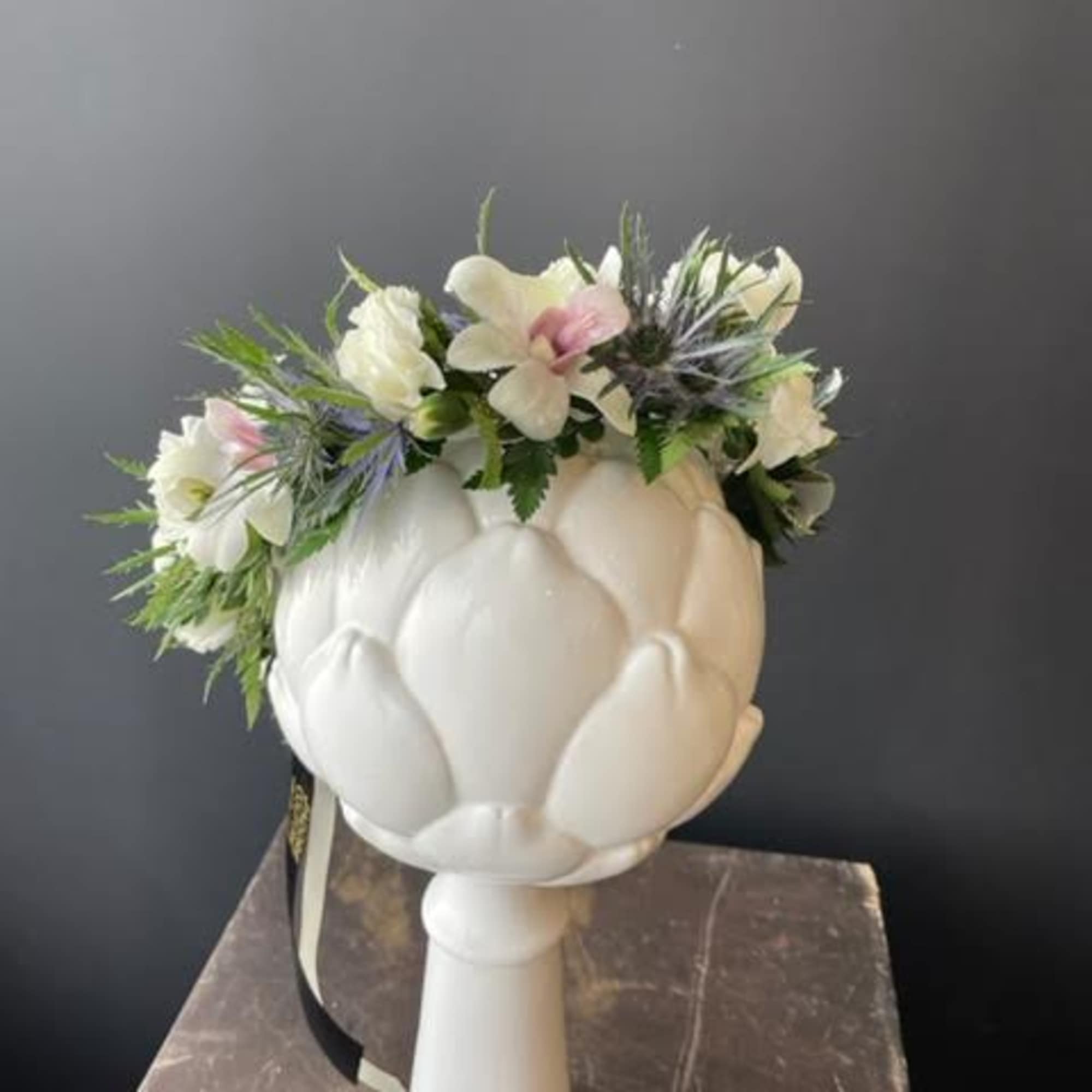White floral crown on a white pedestal vase