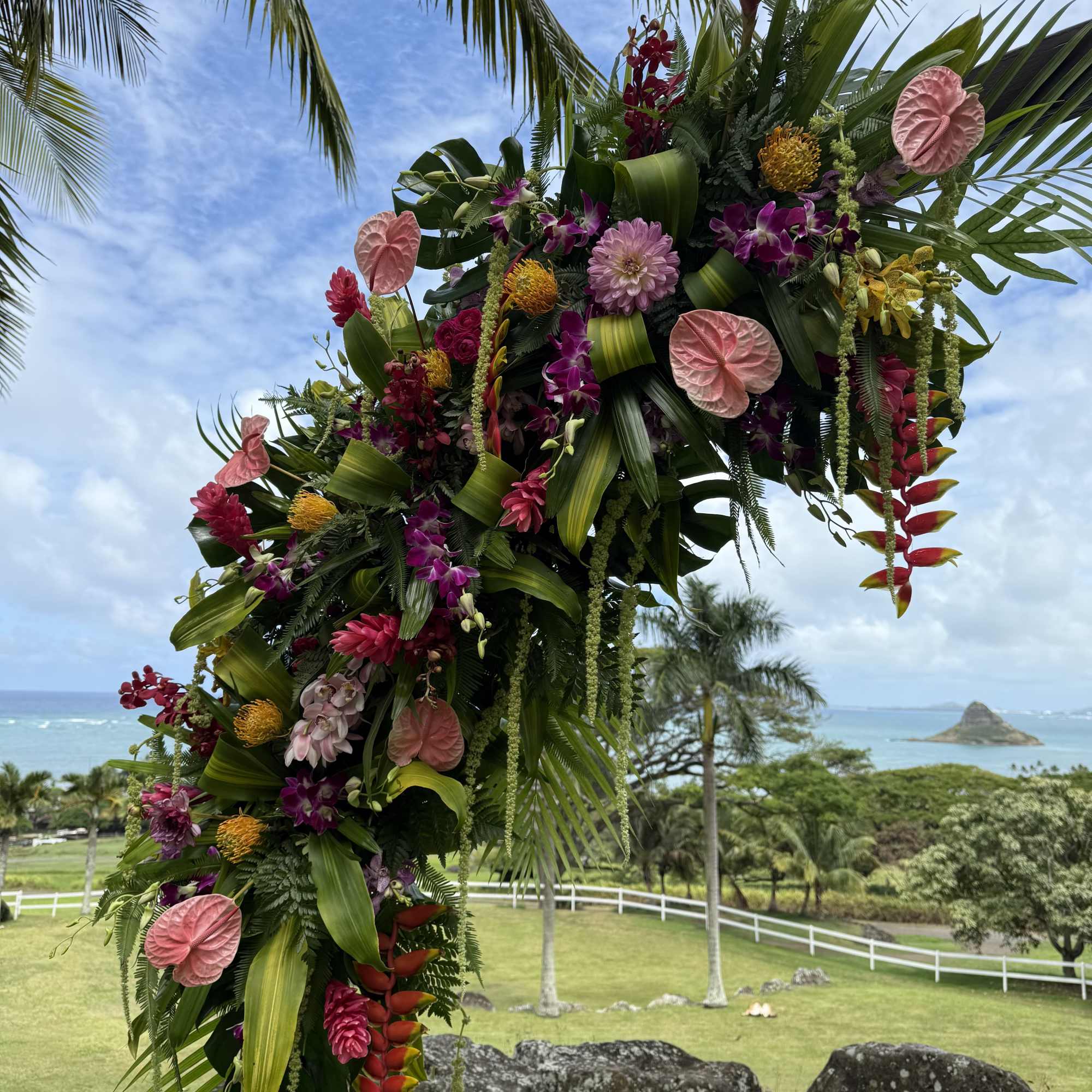 Two large tropical flower designs adorning a circular wedding arch. Circular arch
