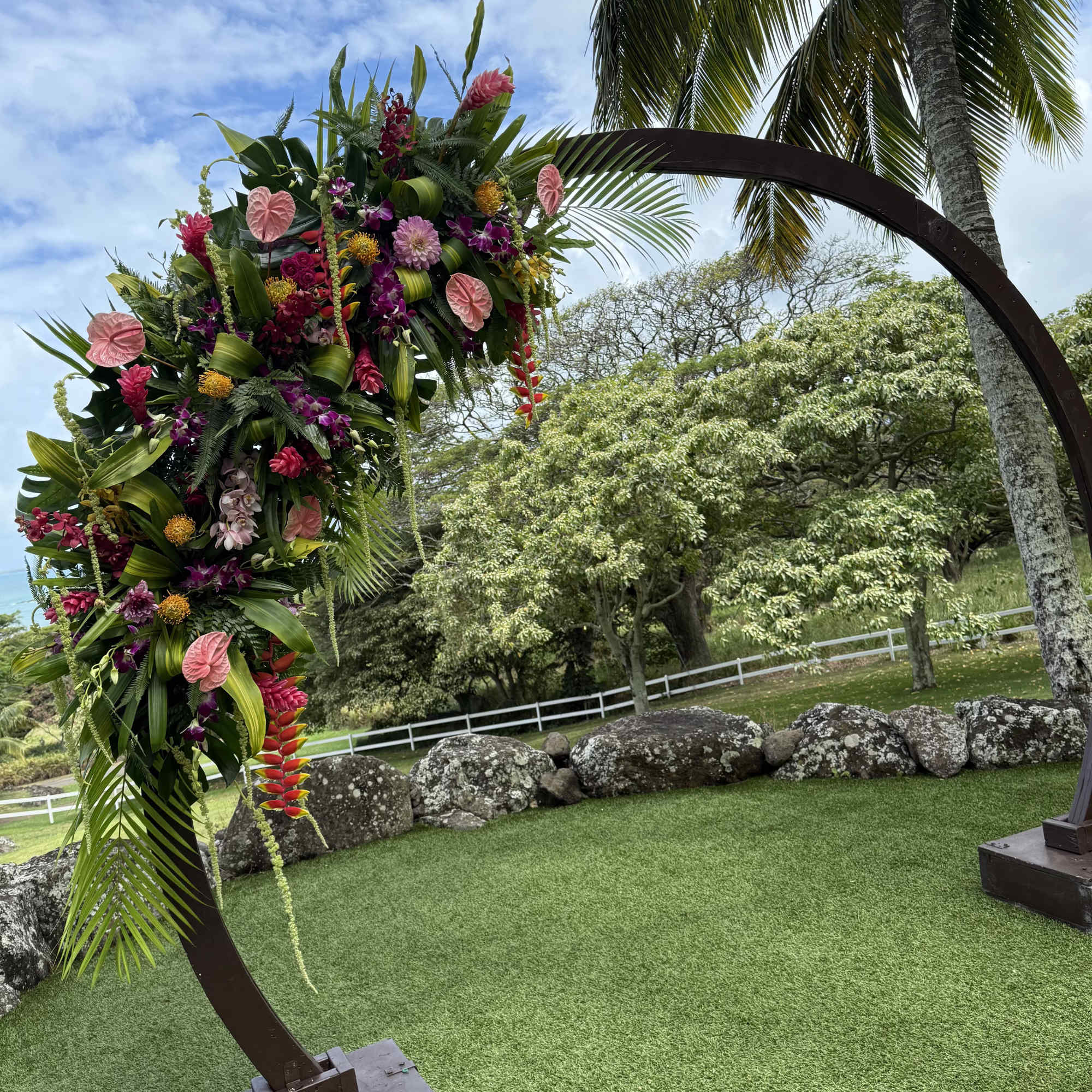 Two large tropical flower designs adorning a circular wedding arch. Circular arch, photo 3 of 3