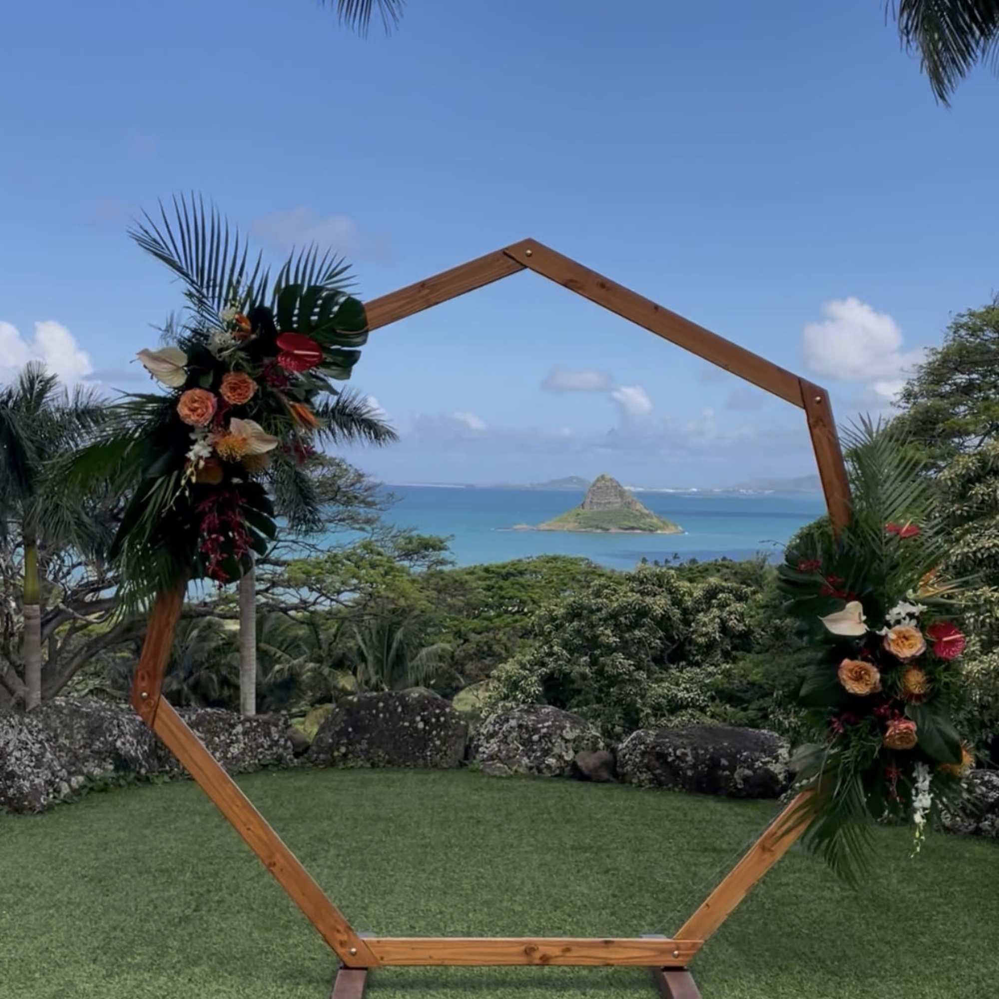 Two large tropical flower designs adorning a circular wedding arch. Circular arch