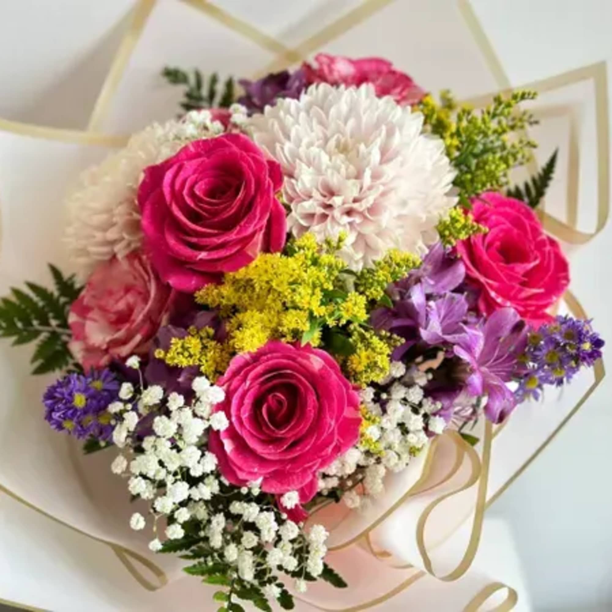 Bouquet of pink roses, white chrysanthemum, and purple flowers wrapped in white paper