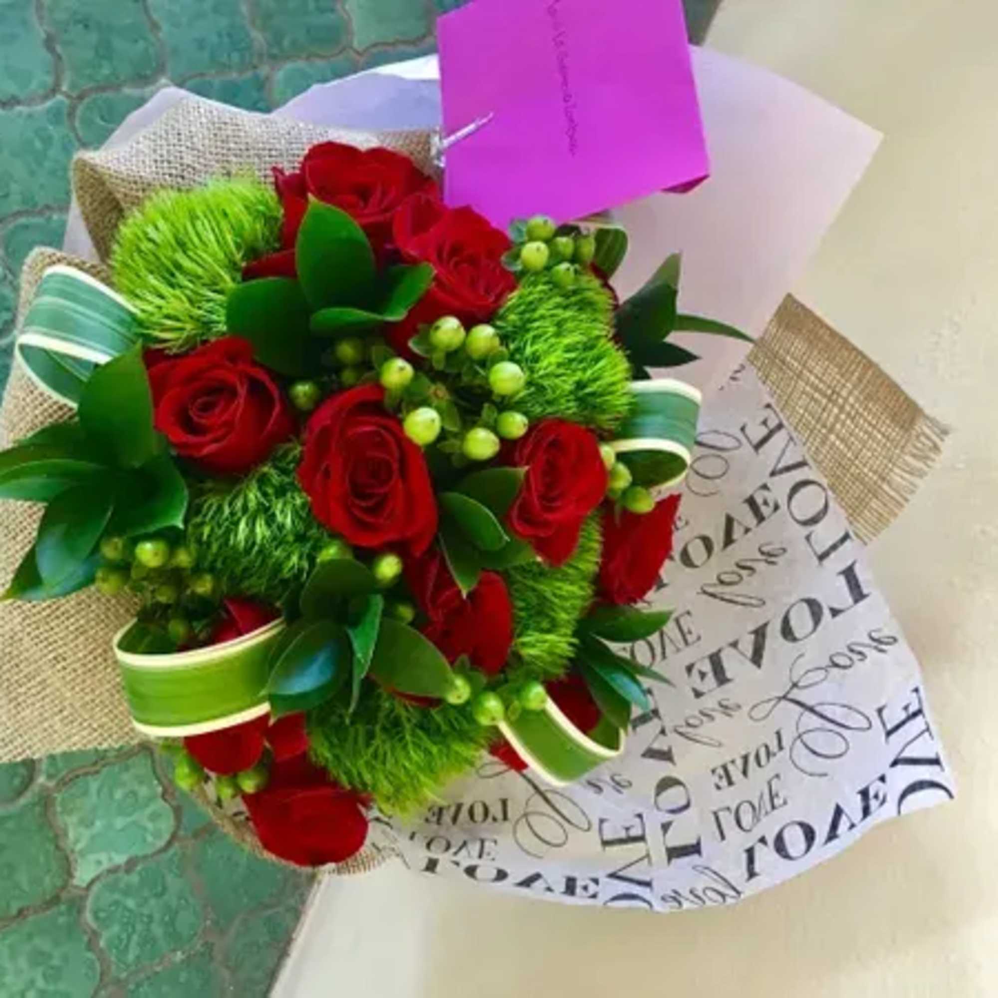 Bouquet of red roses with bright green accents and wrapped paper