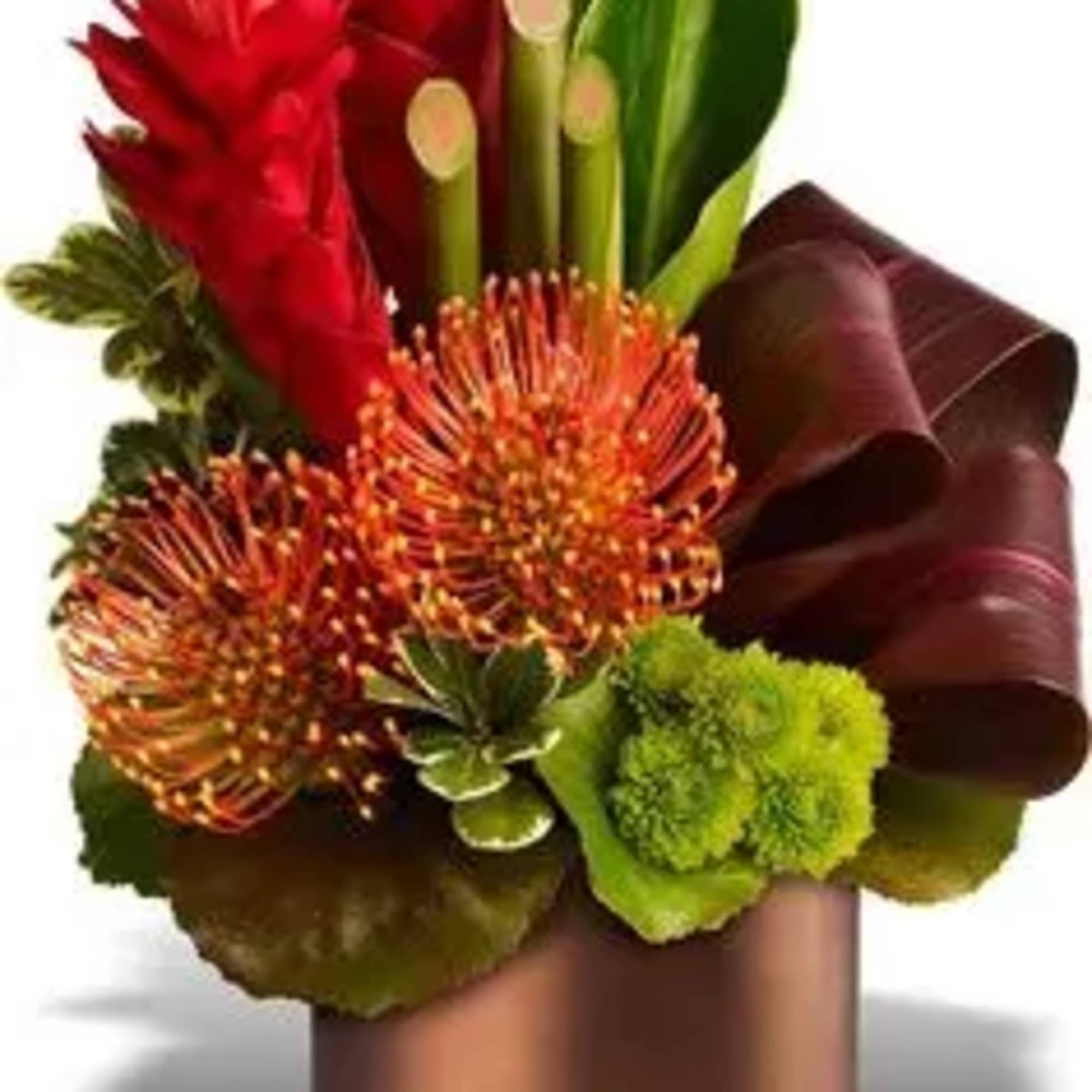 Red and orange tropical flowers arranged in a bronze vase