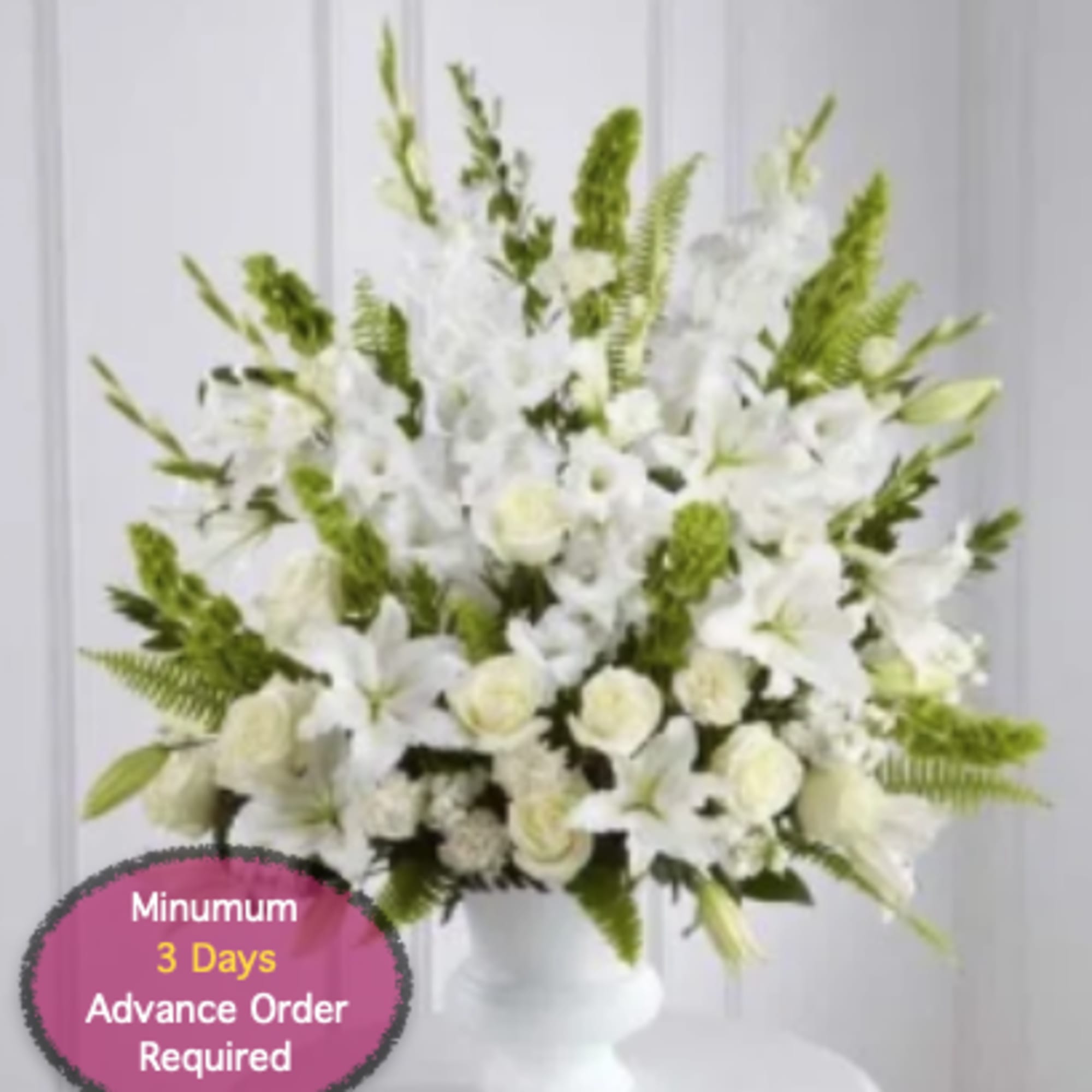 White floral arrangement with lilies and roses in a white vase