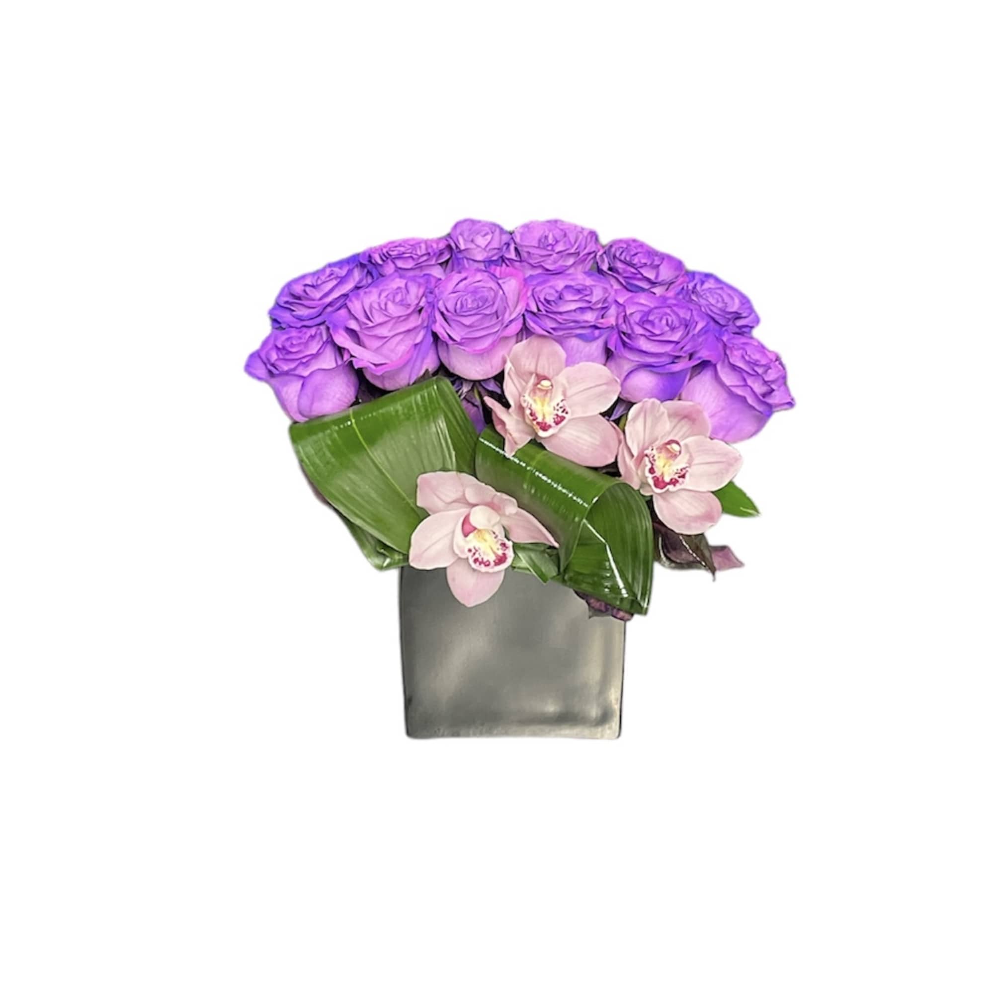 Low arrangement of purple roses and pink orchids with glossy leaves in a gray square vase