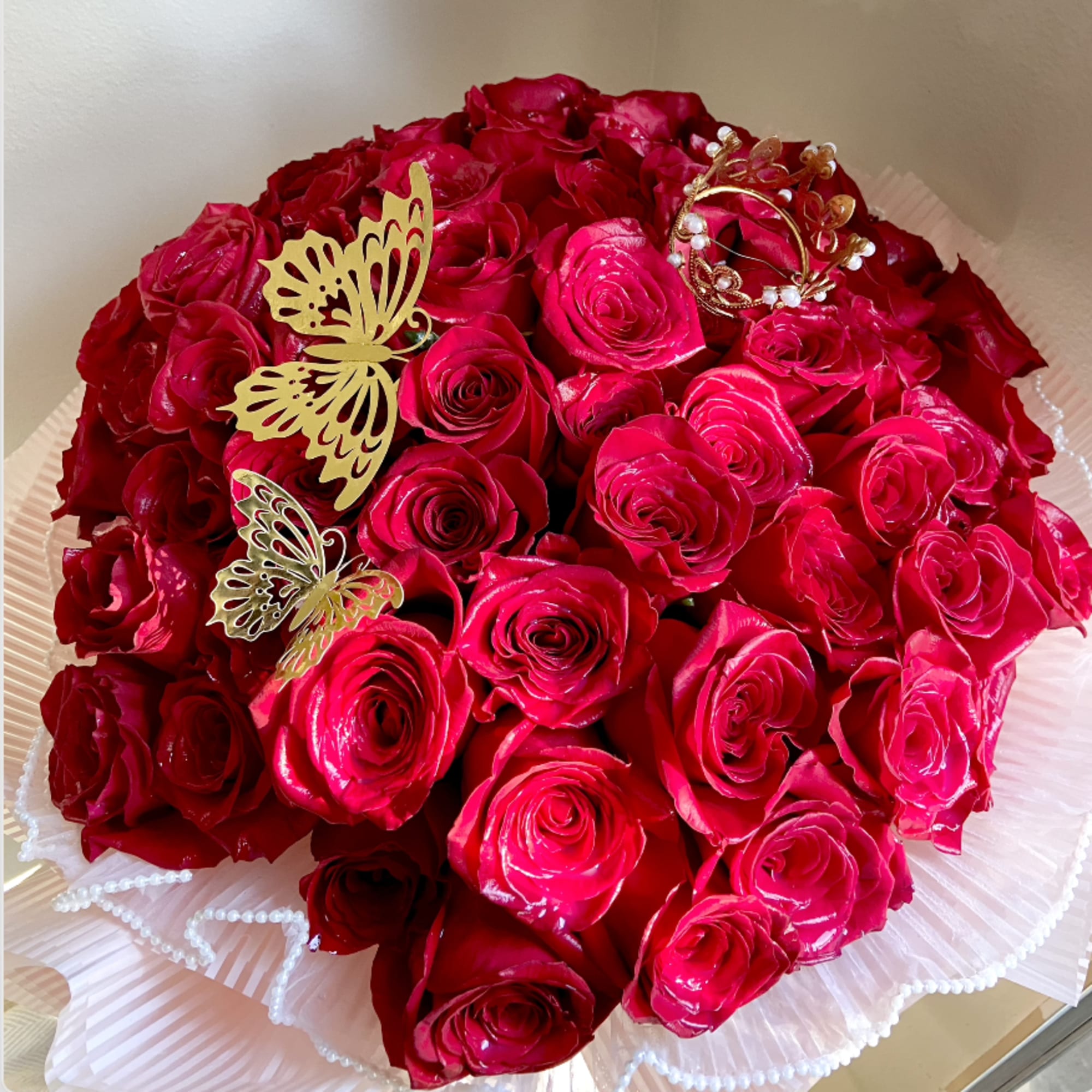 Bouquet of red roses with butterfly decorations and pearl accents