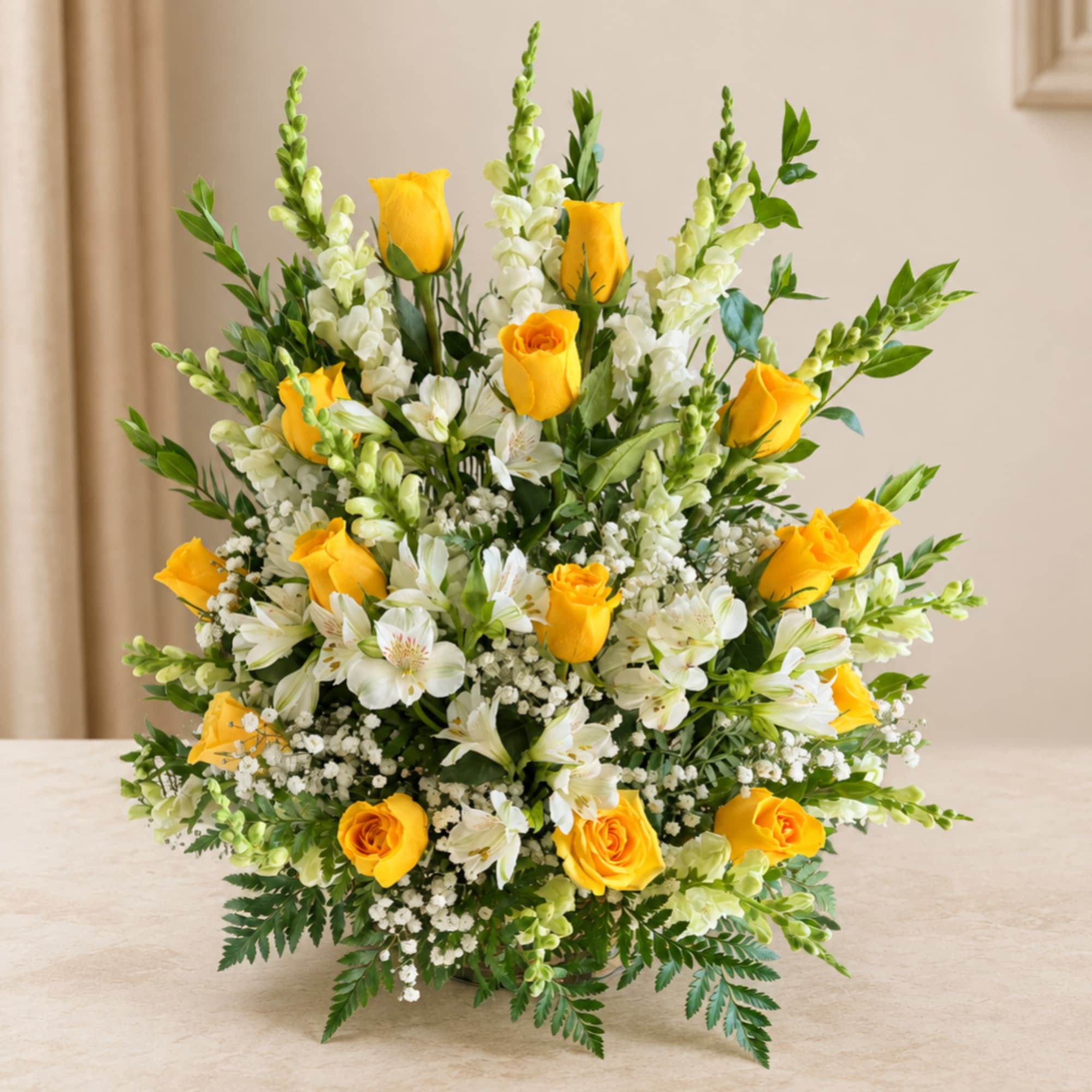 Yellow roses and white flowers arranged in a low vase