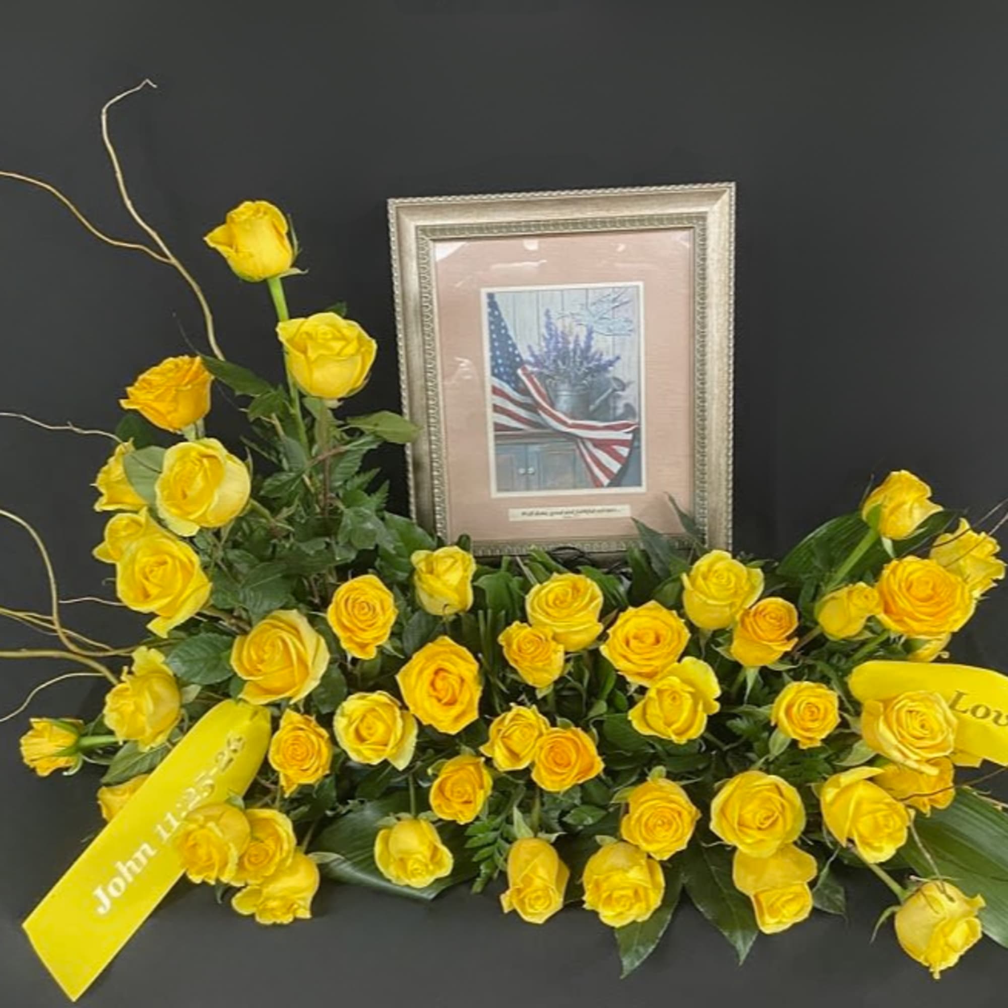 Yellow rose funeral spray with framed tribute and ribbons