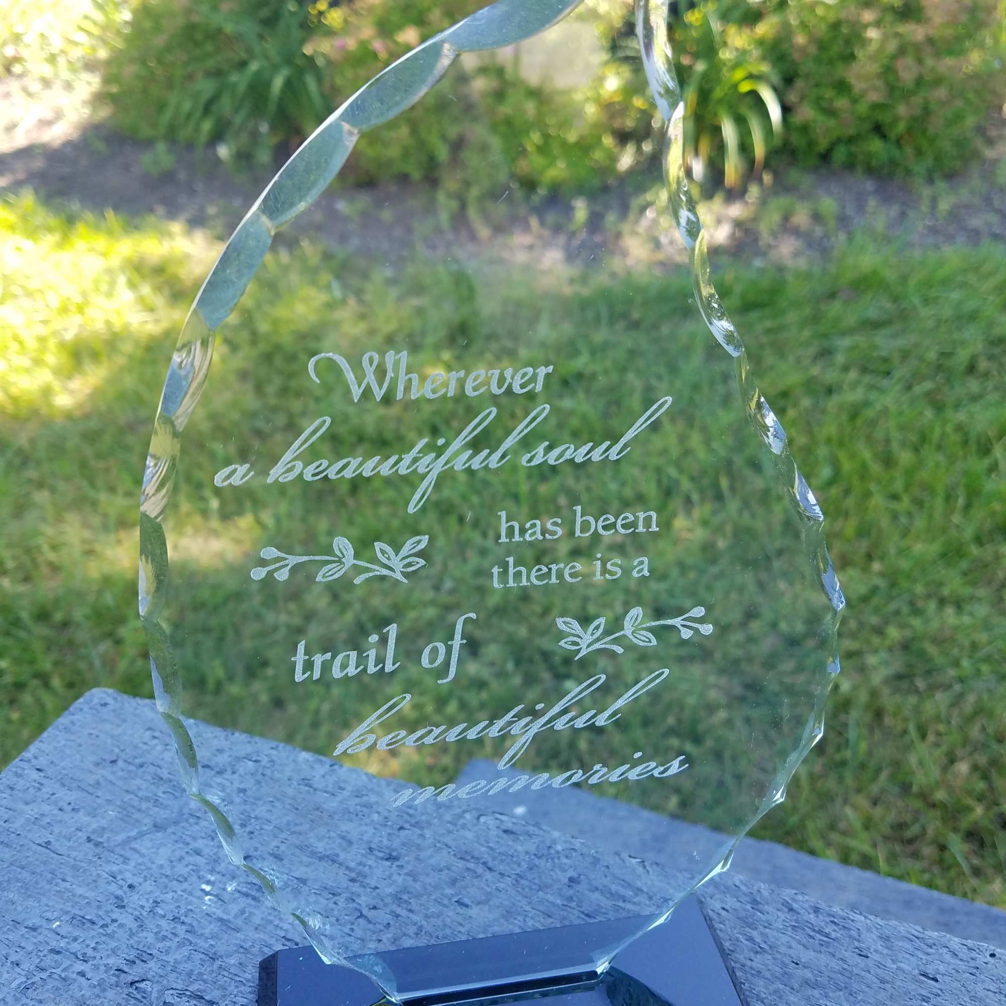 Engraved glass memorial plaque on a black base