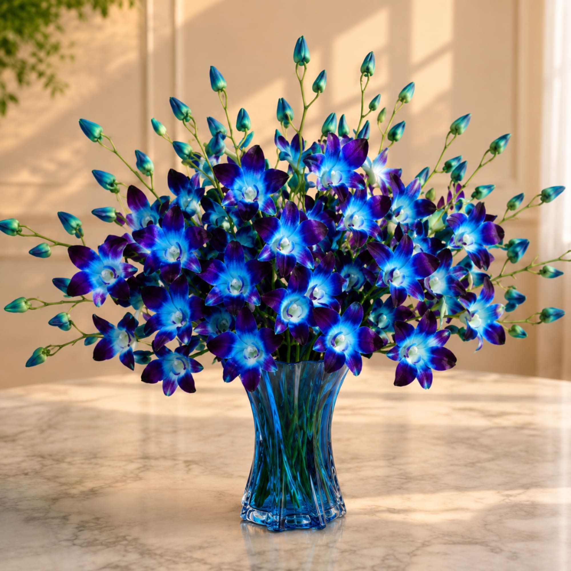 Blue and purple orchid bouquet in a blue glass vase