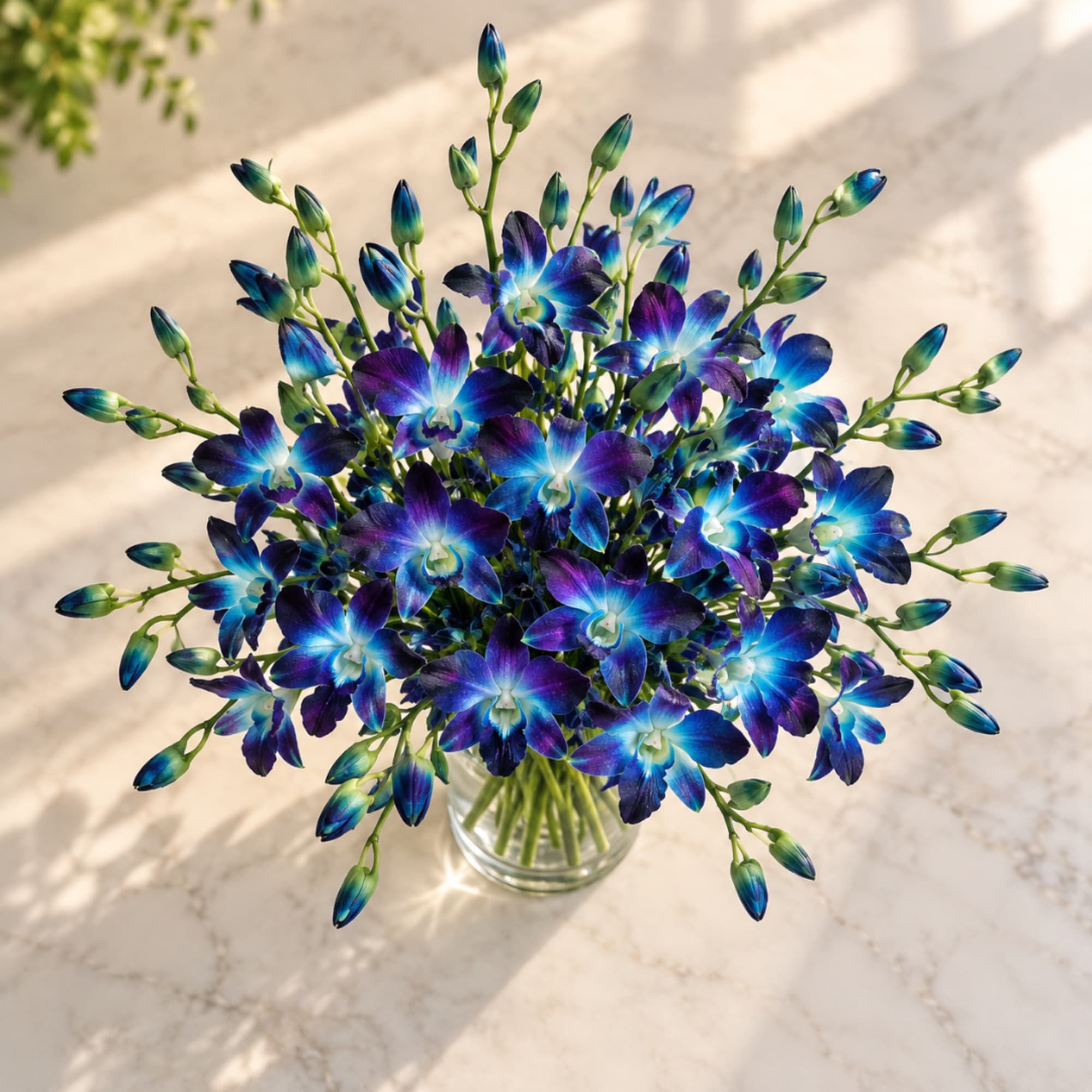Blue and purple orchid bouquet in a clear glass vase