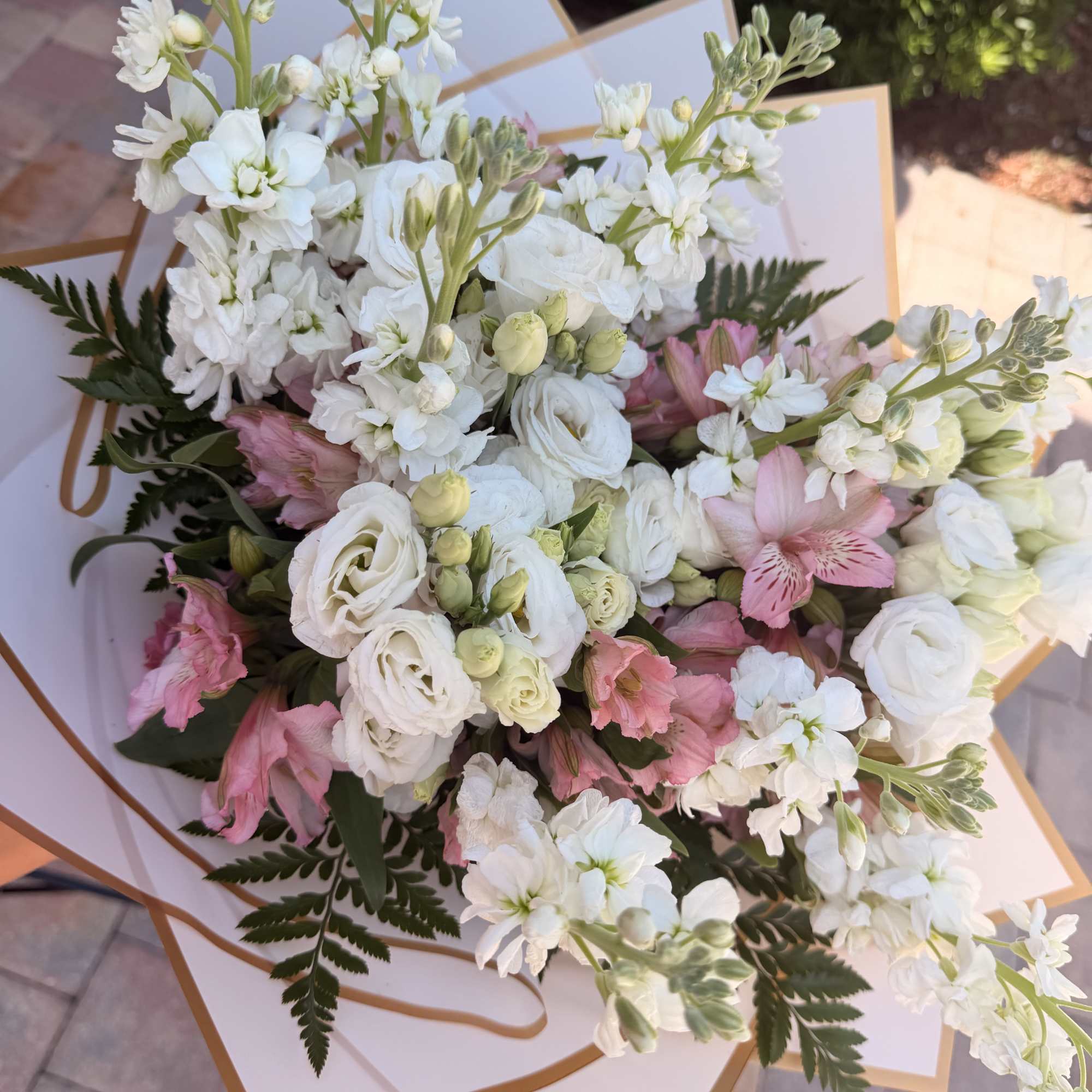 Bouquet of white and pink flowers wrapped in white paper