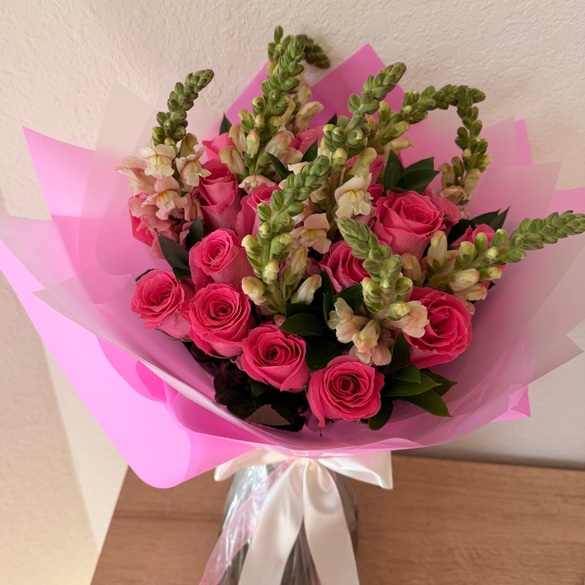Pink rose bouquet with snapdragons wrapped in pink paper
