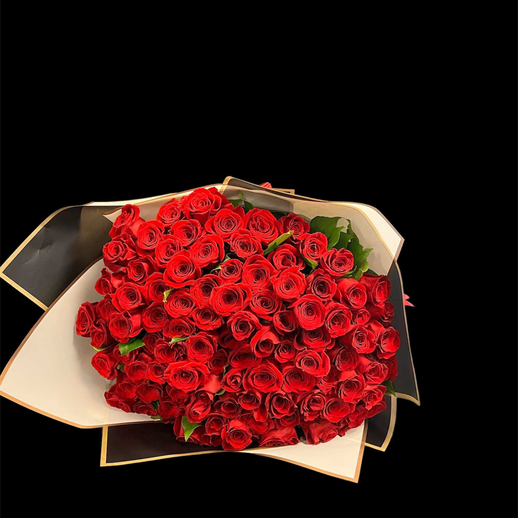 Large bouquet of red roses wrapped in black and cream paper