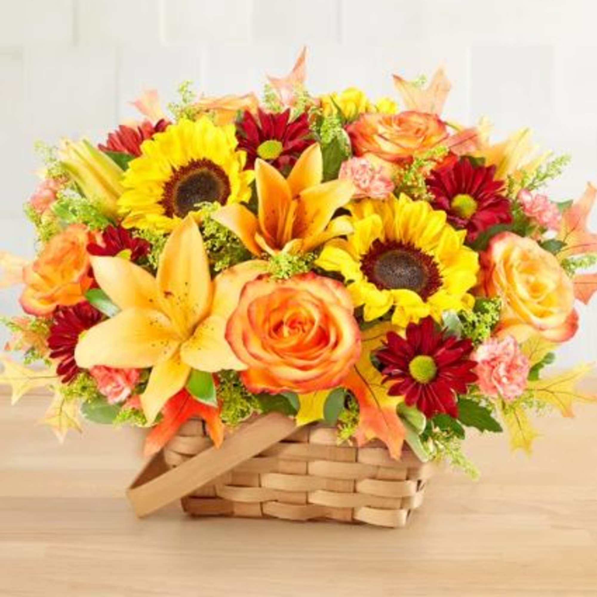 Basket arrangement with sunflowers, lilies, and orange roses