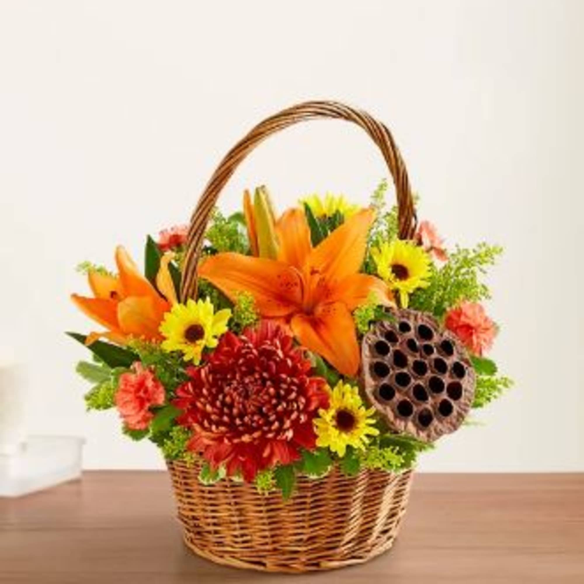 Basket arrangement with orange lilies, yellow daisies, and red chrysanthemums