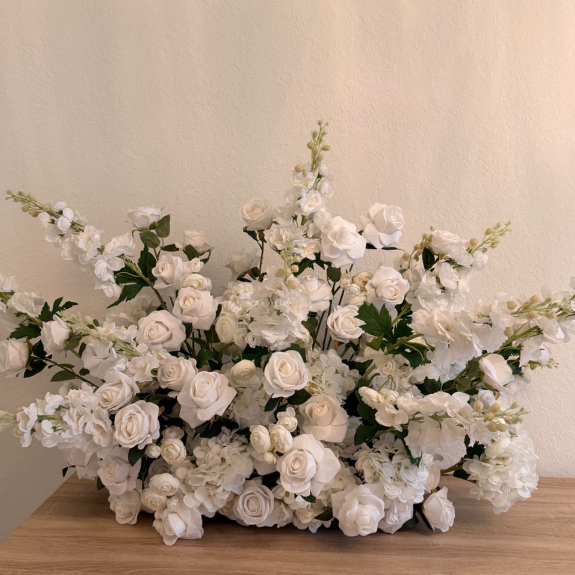 Large white floral arrangement with roses and hydrangea-like blooms
