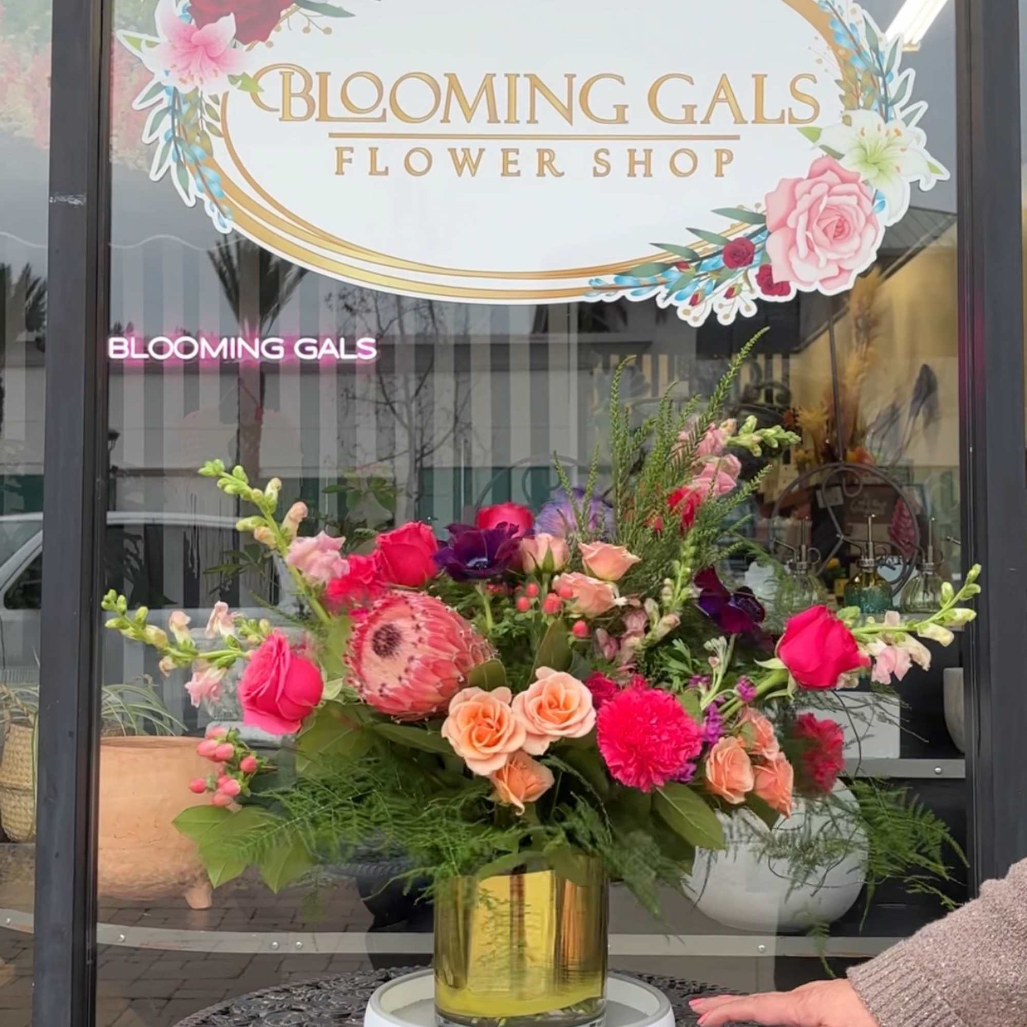 Mixed bouquet in a gold vase with pink, peach, and purple flowers