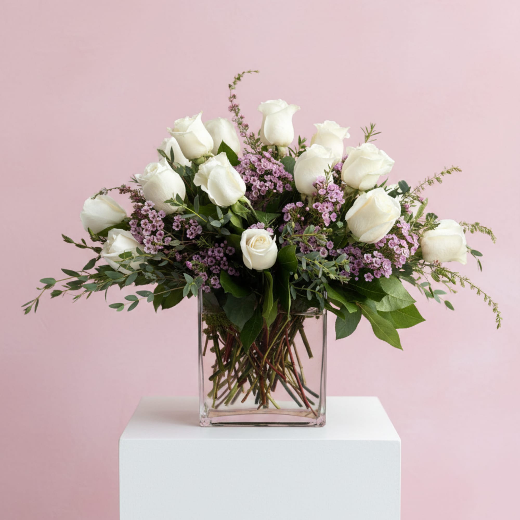 A dozen white roses, lavender waxflower and mixed eucalyptus are perfectly arranged