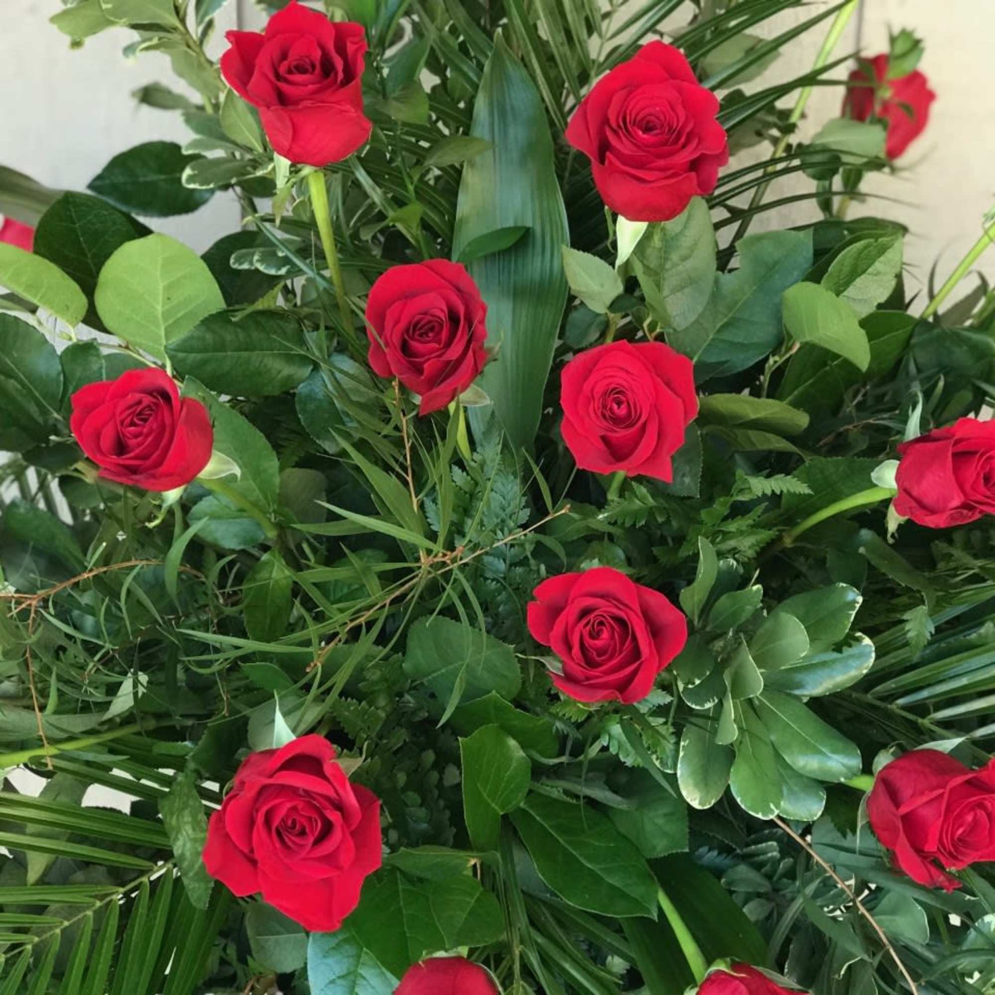Red roses arranged with dense greenery