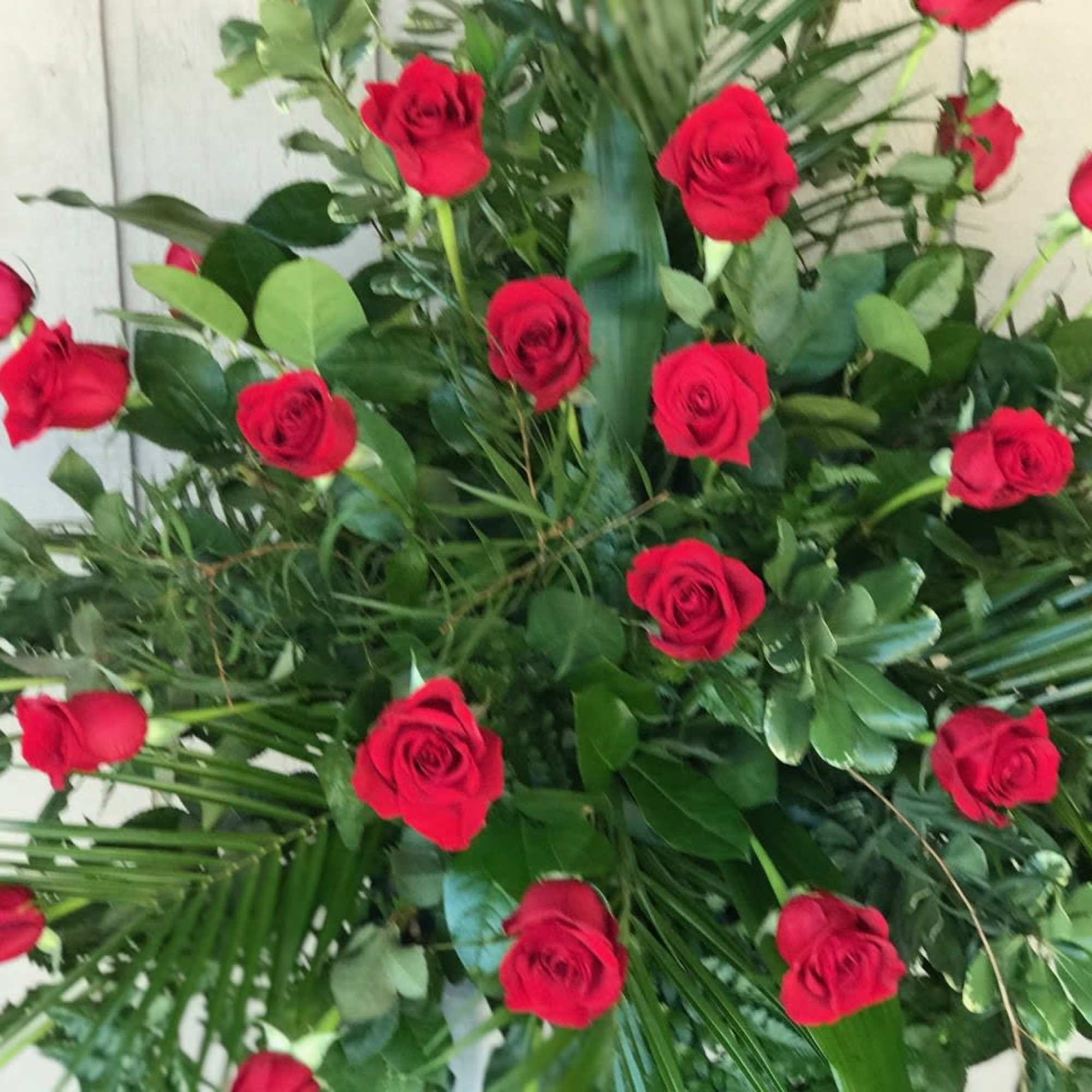 Large arrangement of red roses with mixed greenery
