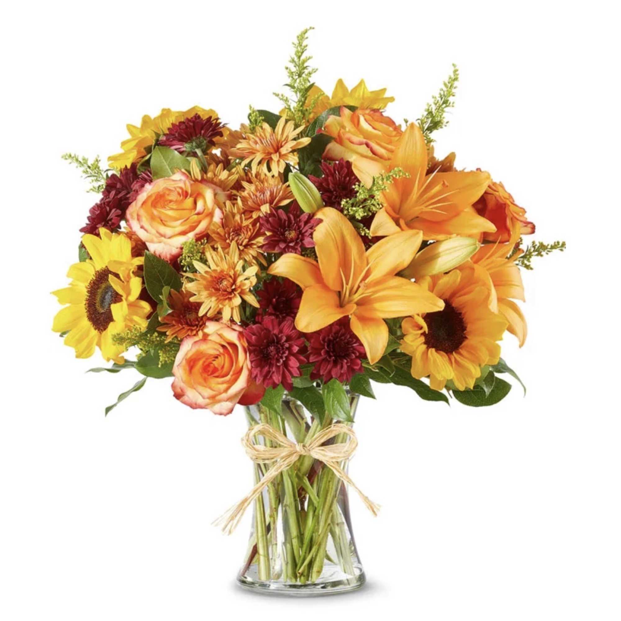 Bouquet of orange lilies, roses, and sunflowers in a clear glass vase