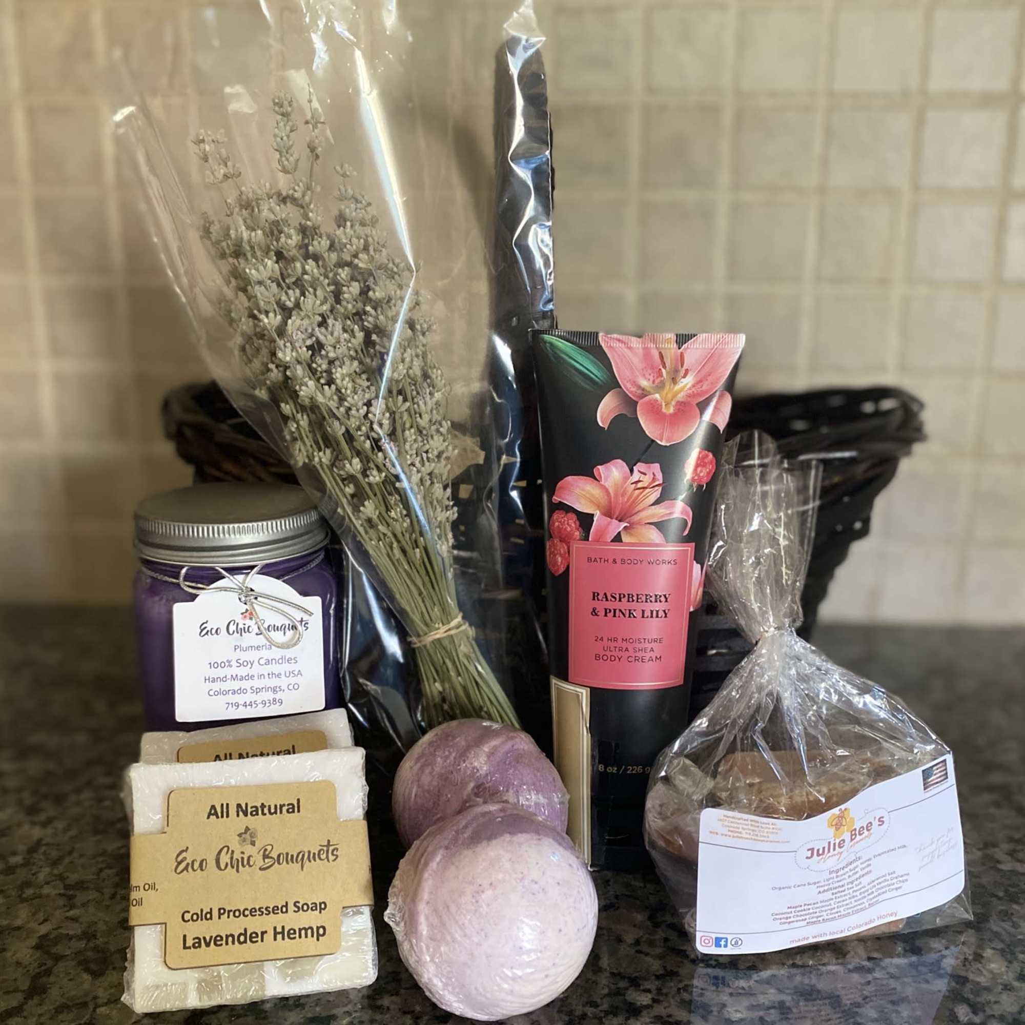 Gift basket with lavender sprigs, soap, bath items, and a candle