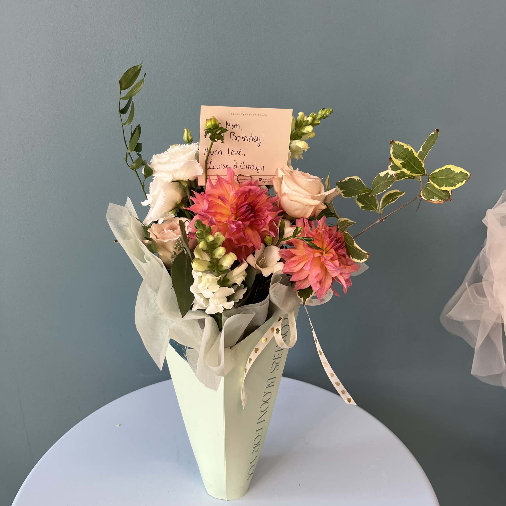 Mixed bouquet with pink and white flowers in a tall wrapped container