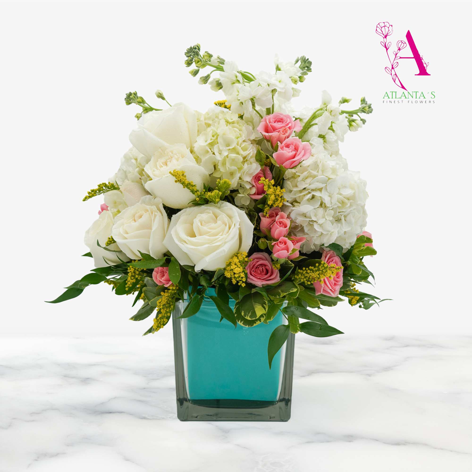 White and pink rose arrangement in a turquoise glass vase