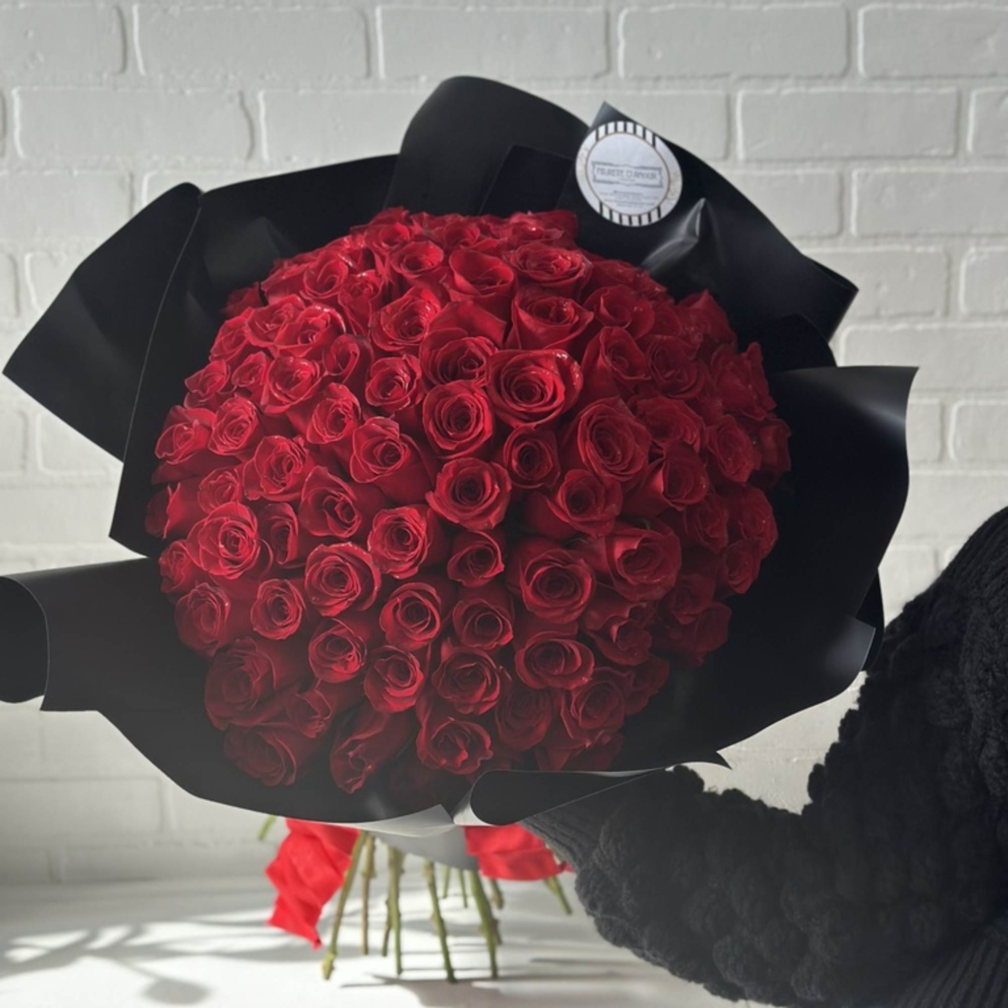 Large bouquet of red roses wrapped in black paper