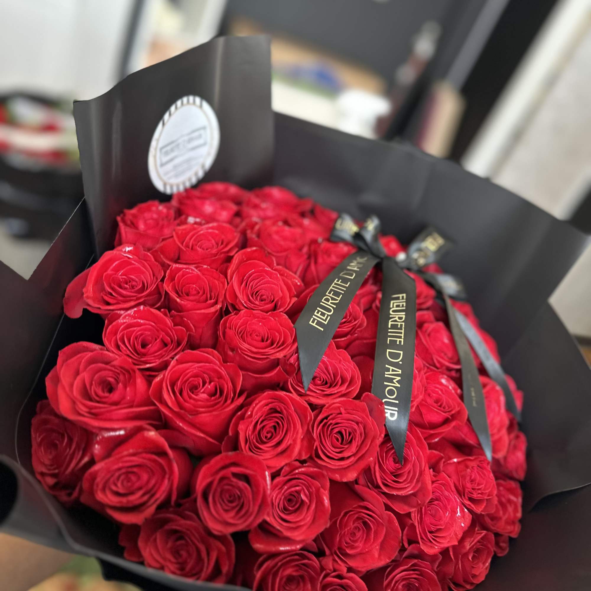 Bouquet of red roses wrapped in black paper with ribbon