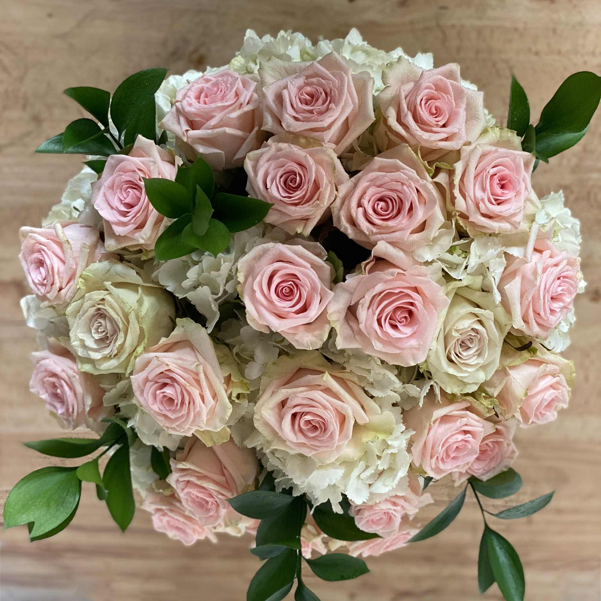 Bouquet of pale pink roses and white hydrangeas with green foliage