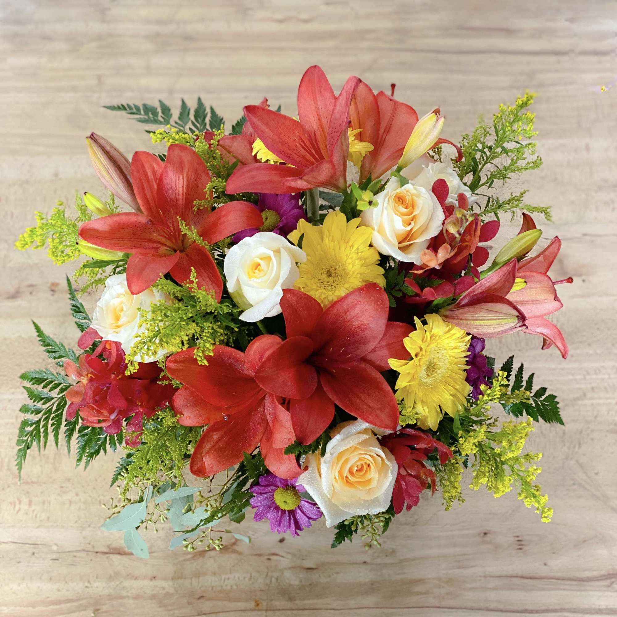 Bouquet of red lilies, white roses, and yellow daisies
