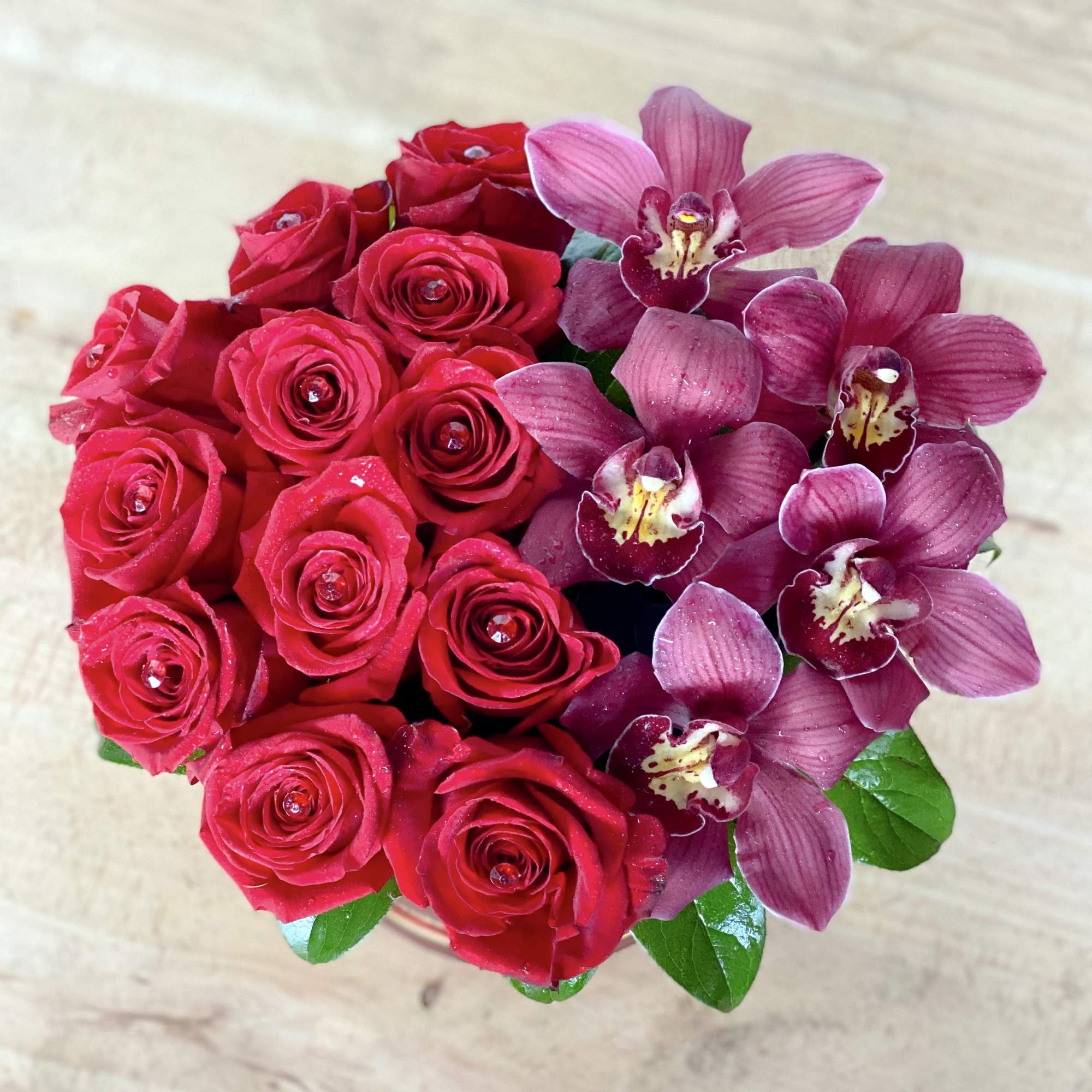 Red roses and purple orchids in a compact bouquet