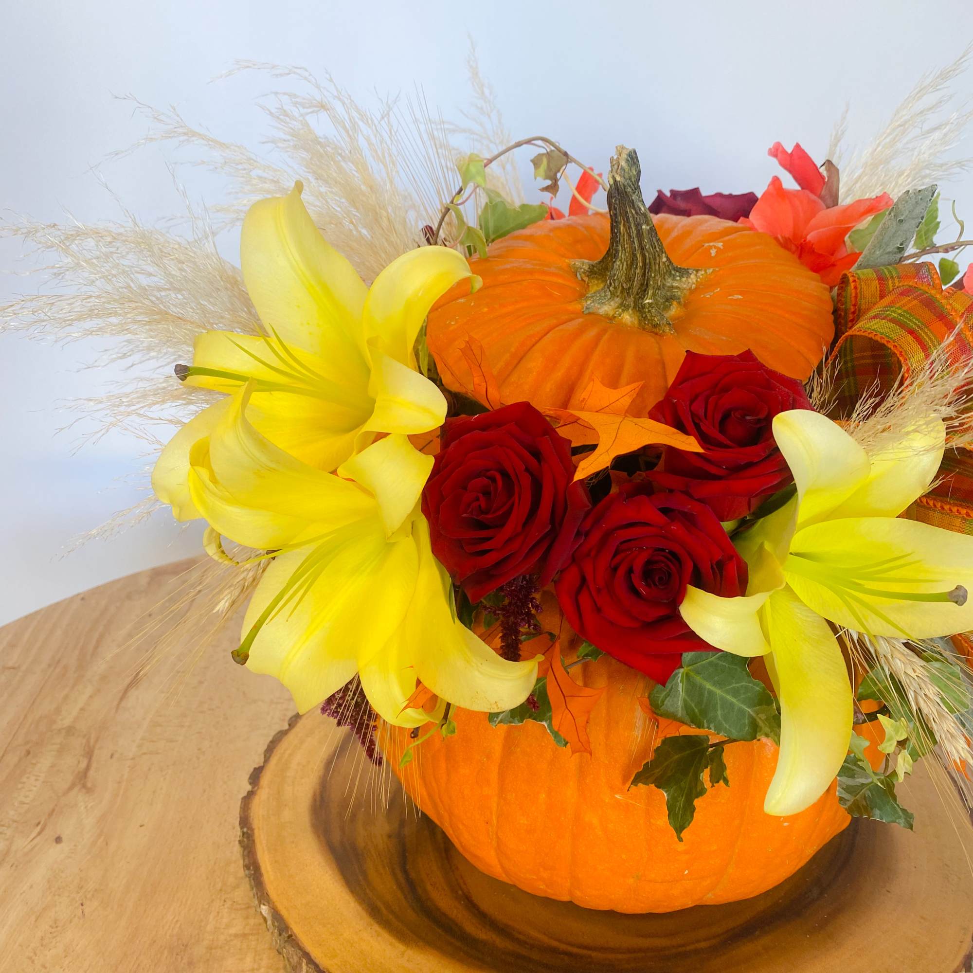 Pumpkin centerpiece with red roses and yellow lilies, photo 3 of 3